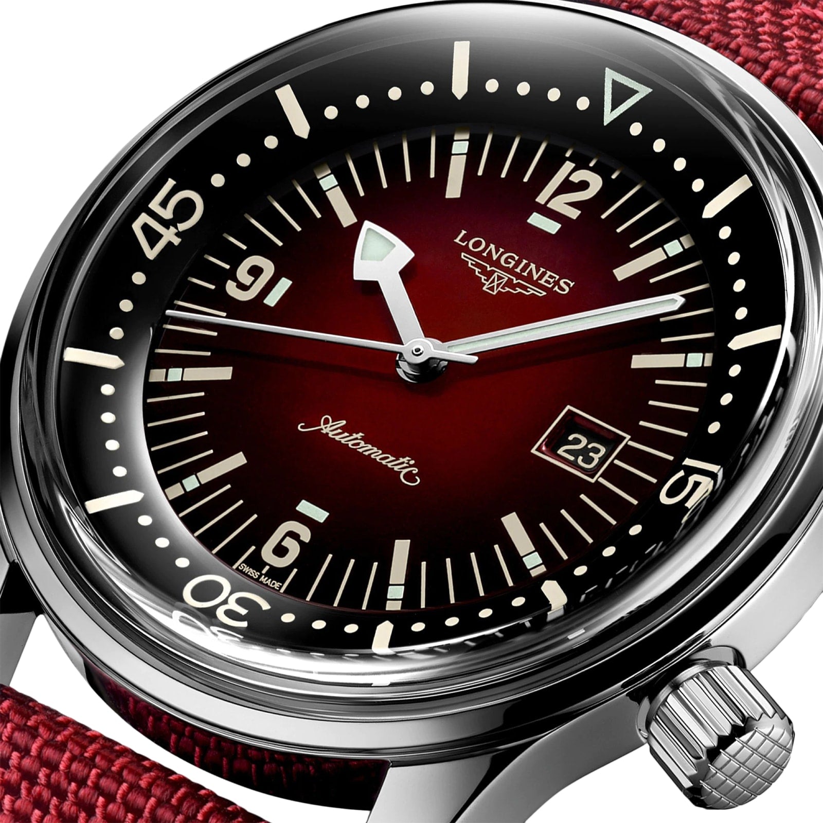 Close-up of the Longines Legend Diver watch featuring a red dial, black bezel, white markers, date window at 3 o’clock, and a red fabric strap.