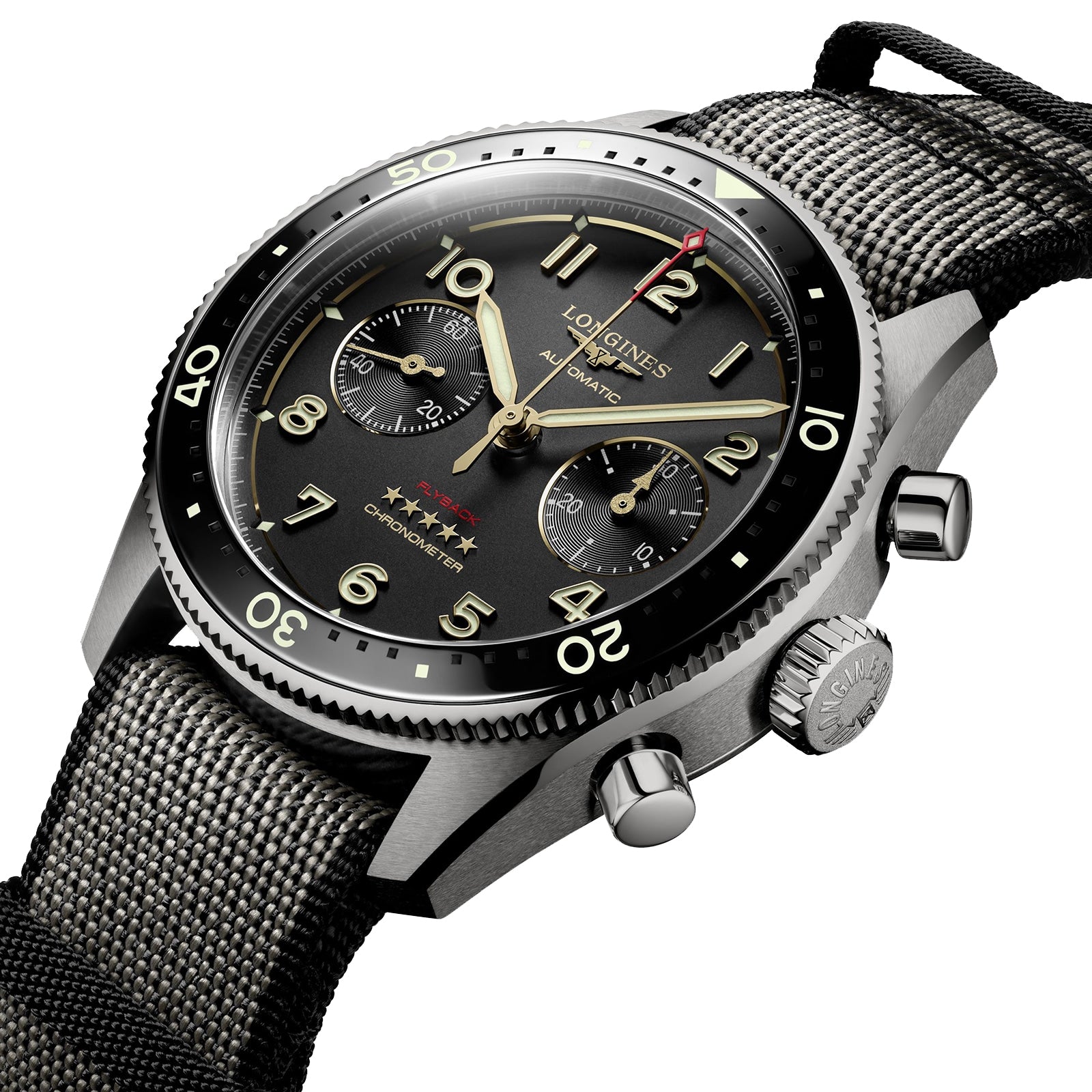 A close-up of the Longines Spirit Flyback Titanium, a pilot chronograph featuring a titanium case, black dial with three subdials, rotating bezel, and a textured fabric strap.