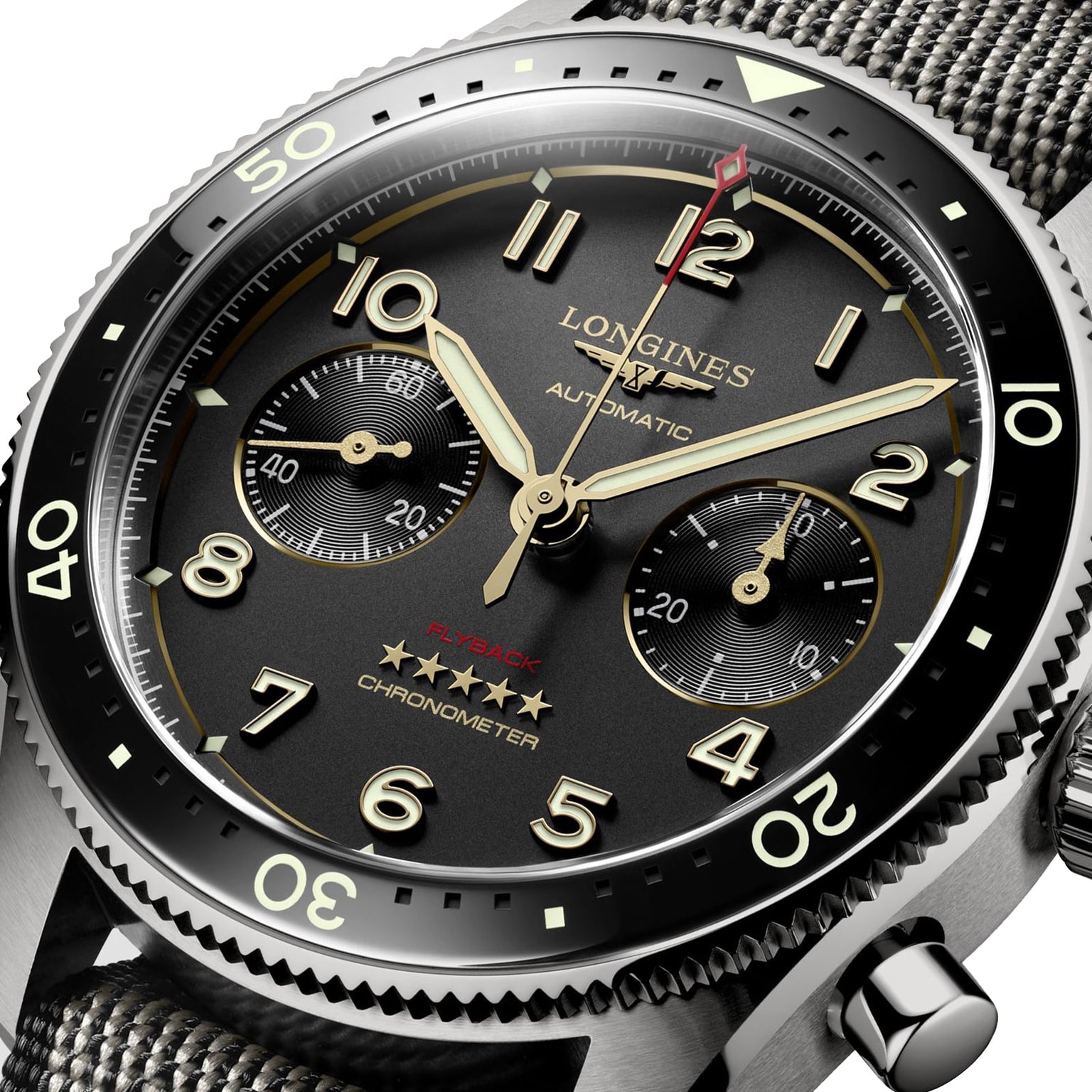 Close-up of the Longines Spirit Flyback Titanium, featuring a black dial, gold hands, two subdials, and a fabric strap in a sleek titanium case.