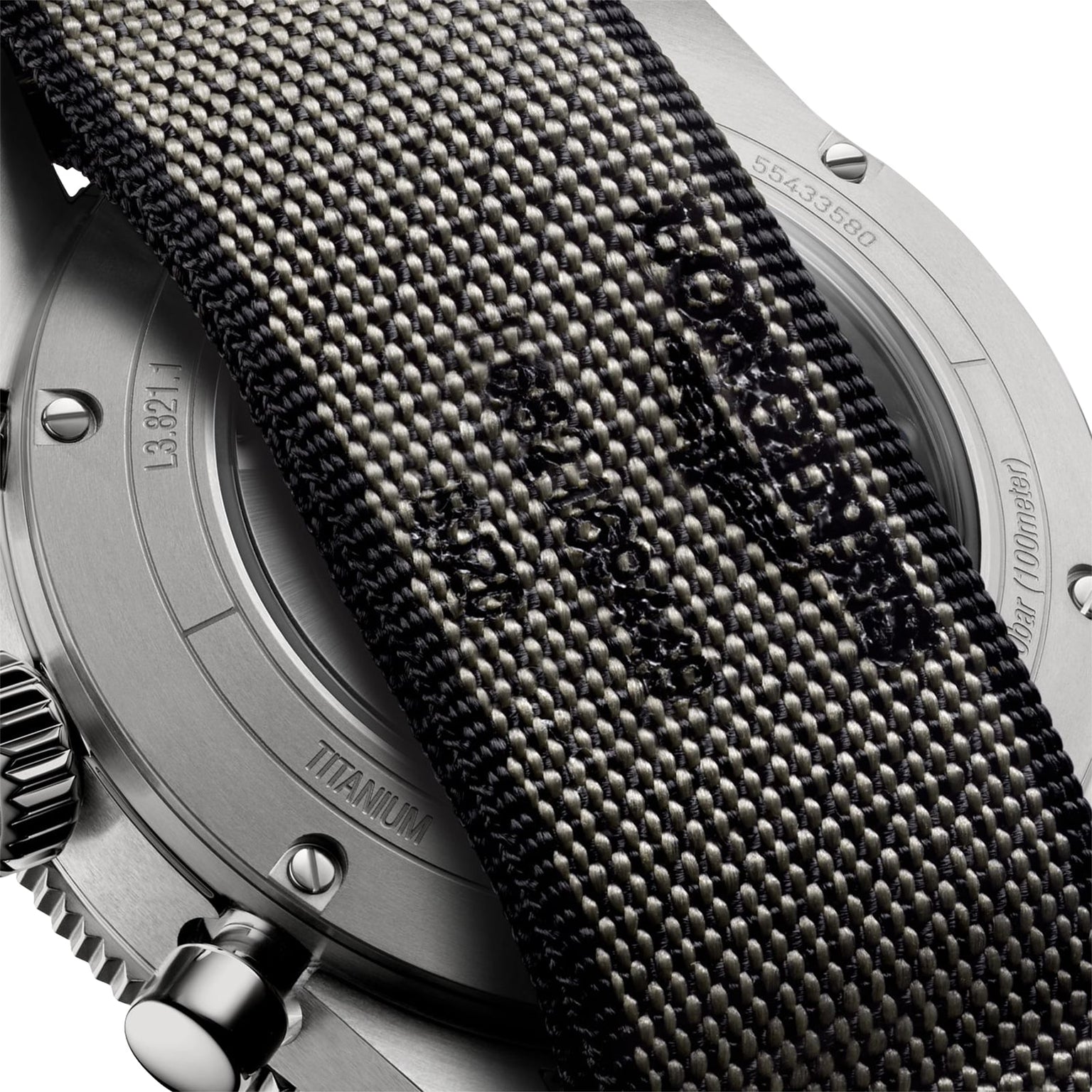 Close-up of the Longines Spirit Flyback Titaniums back, highlighting its titanium case, partly covered by a textured fabric strap with visible stitching and embossed text.