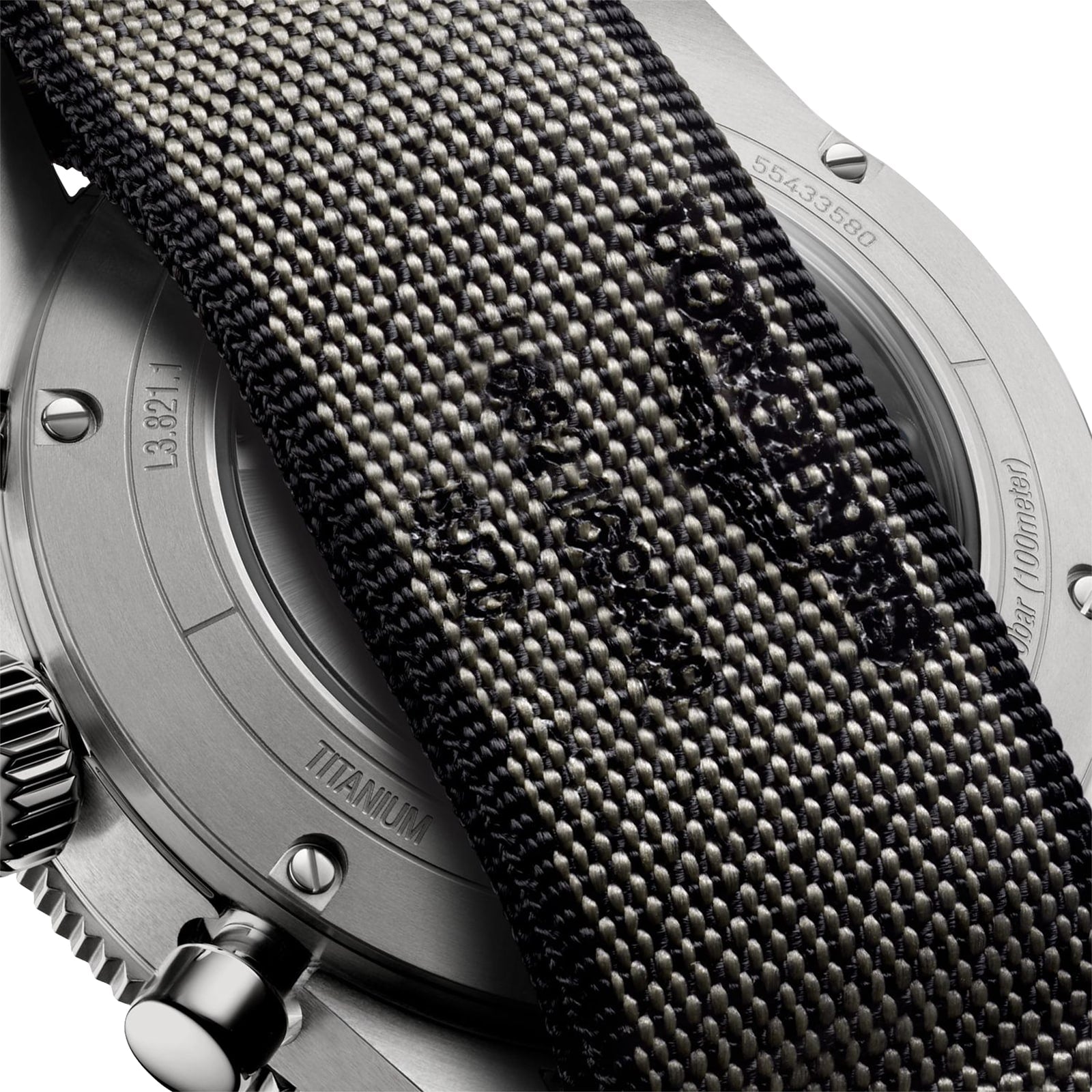 Close-up of the Longines Spirit Flyback Titaniums back, highlighting its titanium case, partly covered by a textured fabric strap with visible stitching and embossed text.