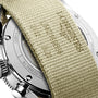 Close-up of the back of the Longines Spirit Flyback wristwatch, showcasing its chronometer status, with a beige woven fabric strap partially covering the engraved case back.