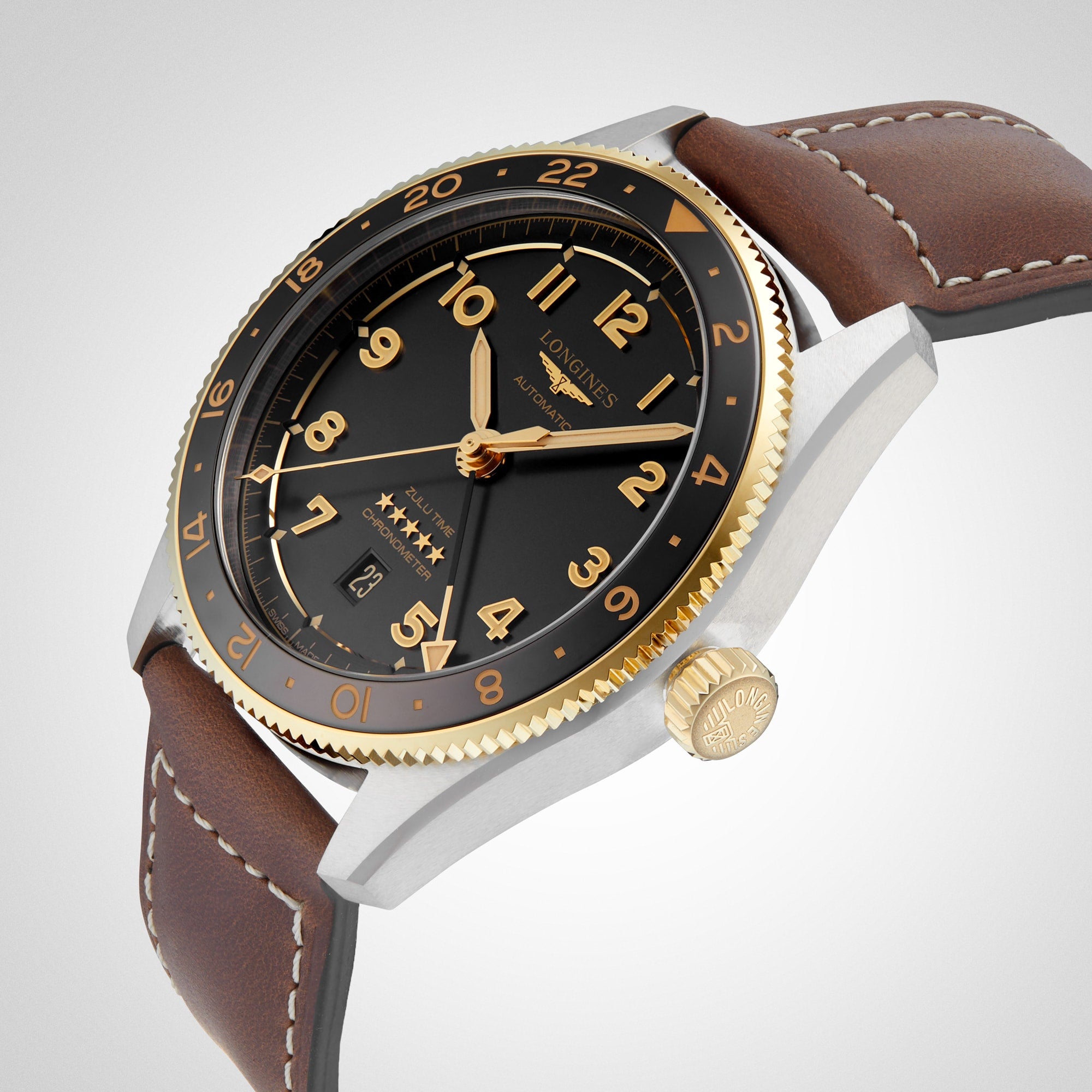 A close-up of the Longines Spirit Zulu Time, featuring a black and gold bezel, black dial with gold numerals, and a brown leather strap—a chronometer-certified watch crafted for explorers.