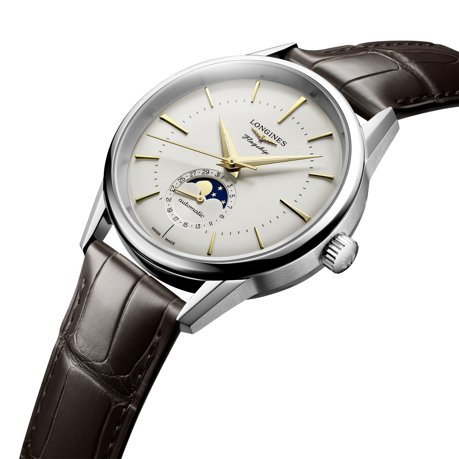 The Longines Flagship Heritage Moonphase wristwatch features a silver case, brown leather strap, gold hands and markers, and a moon phase display at 6 o’clock on a white dial.