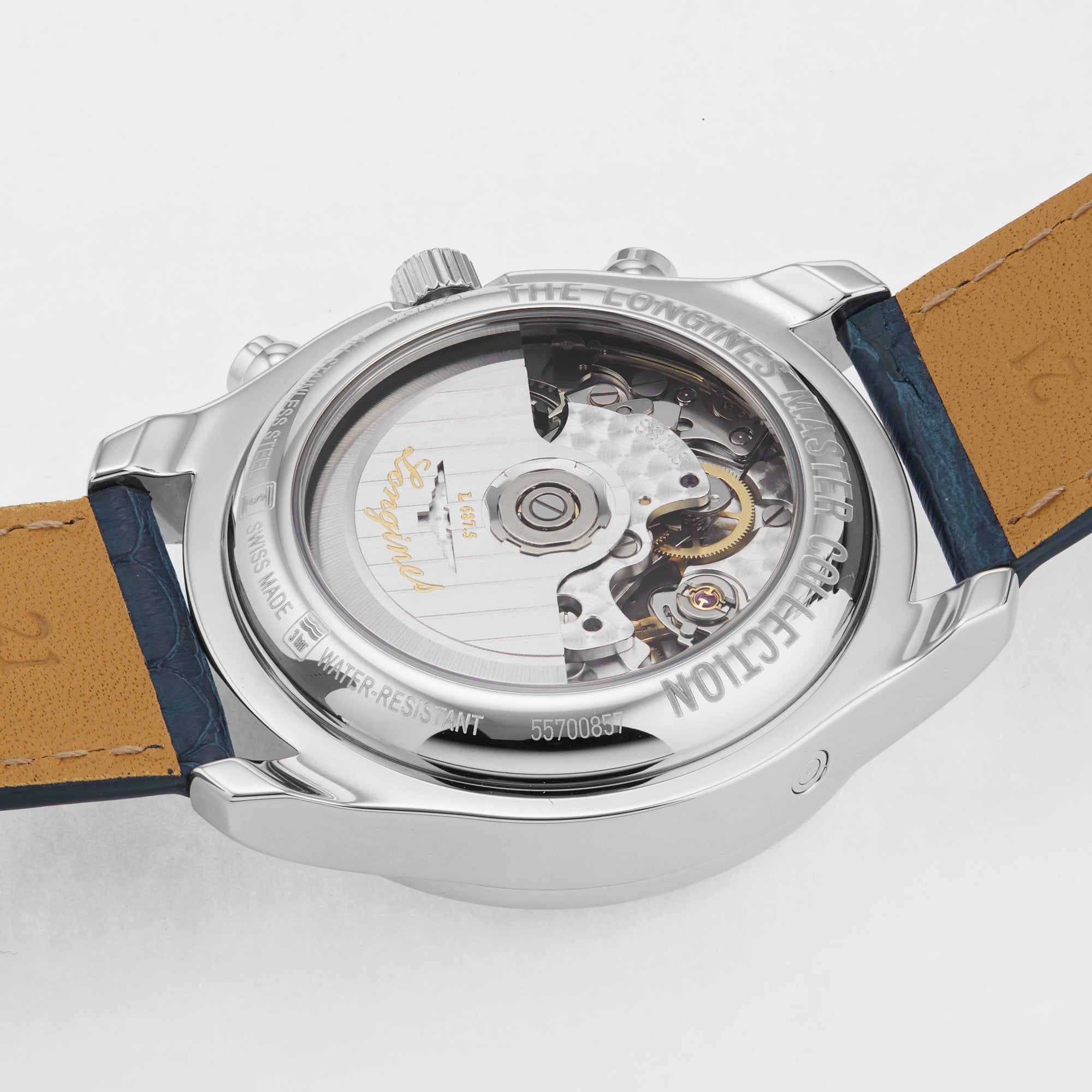 A close-up of the Longines Master Collection Chrono Moonphase showcases its exposed L687 calibre through a transparent case back, with visible leather strap and engraved text reflecting the artistry of fine chronographs.