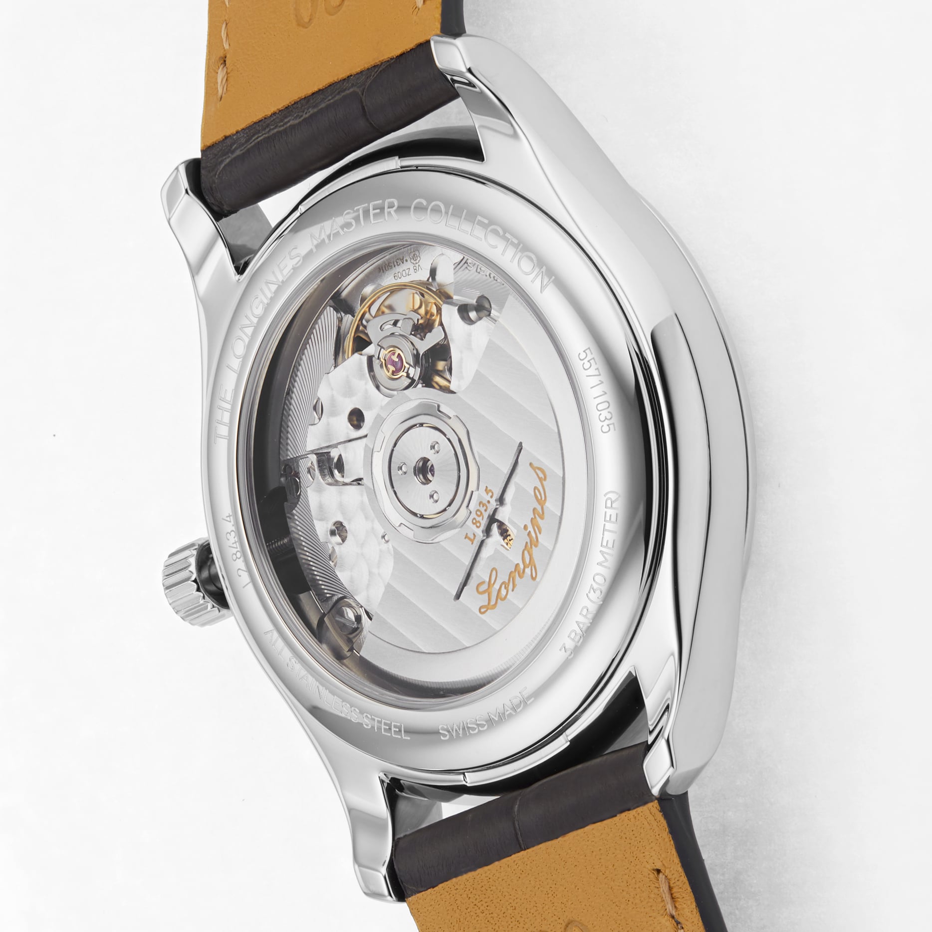 Close-up of the Longines Master Collection watch’s transparent case back, showing its self-winding movement, detailed engravings, and a brown leather strap.