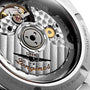 Close-up of a Longines Conquest automatic watch movement displaying gears, rotor, and engraved branding inside a stainless steel case.