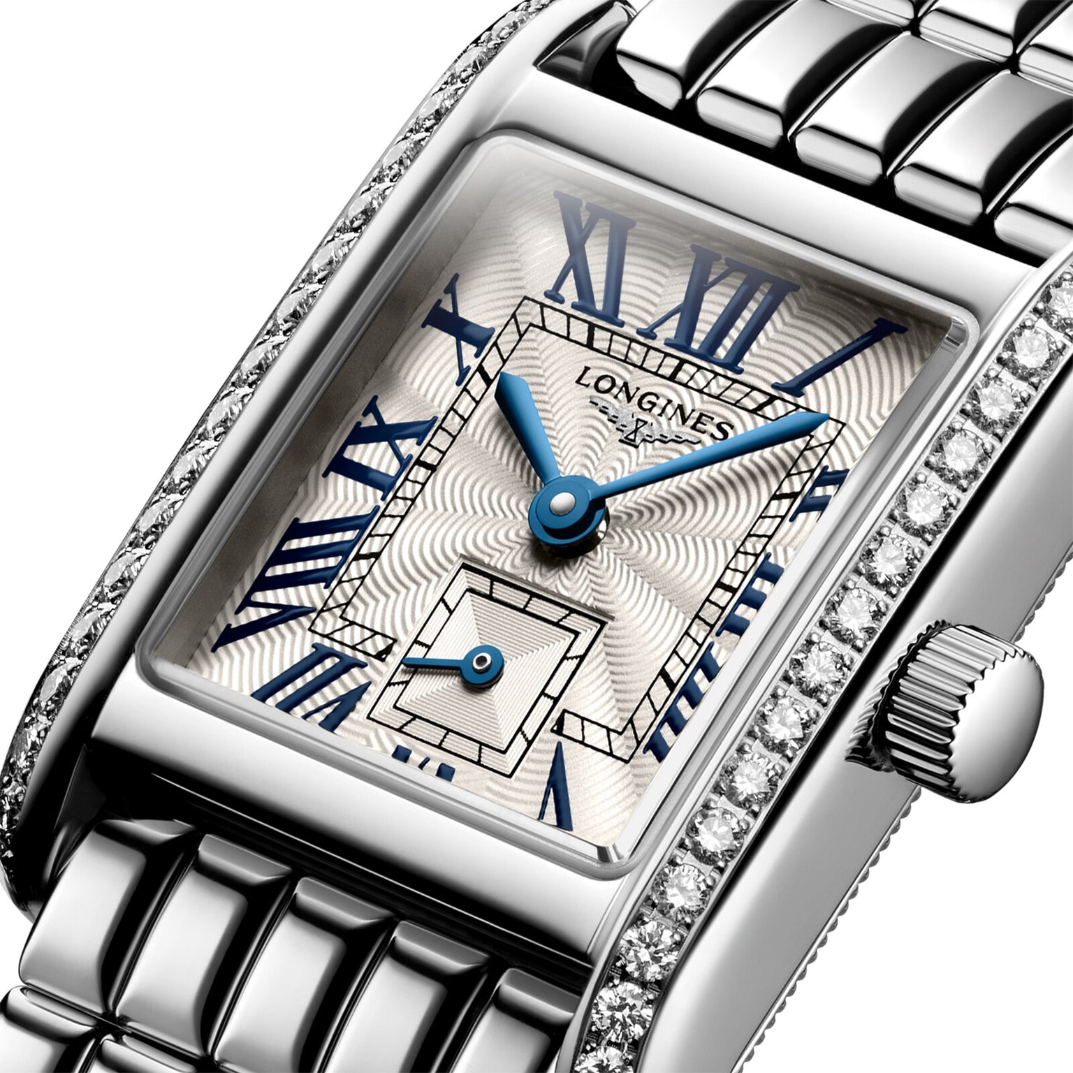 Close-up of the Longines Mini DolceVita wristwatch with a stainless steel case, rectangular dial, blue hands, Roman numerals, Top Wesselton diamond-set bezel, and a metal link bracelet.