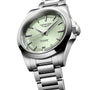 The Longines Conquest features a silver case, mint green dial, metal bracelet, and date display at 6 o’clock.