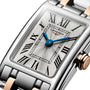 The Longines Dolcevite features a rectangular case, silver dial with blue hands, Roman numerals, and a two-tone metal band.