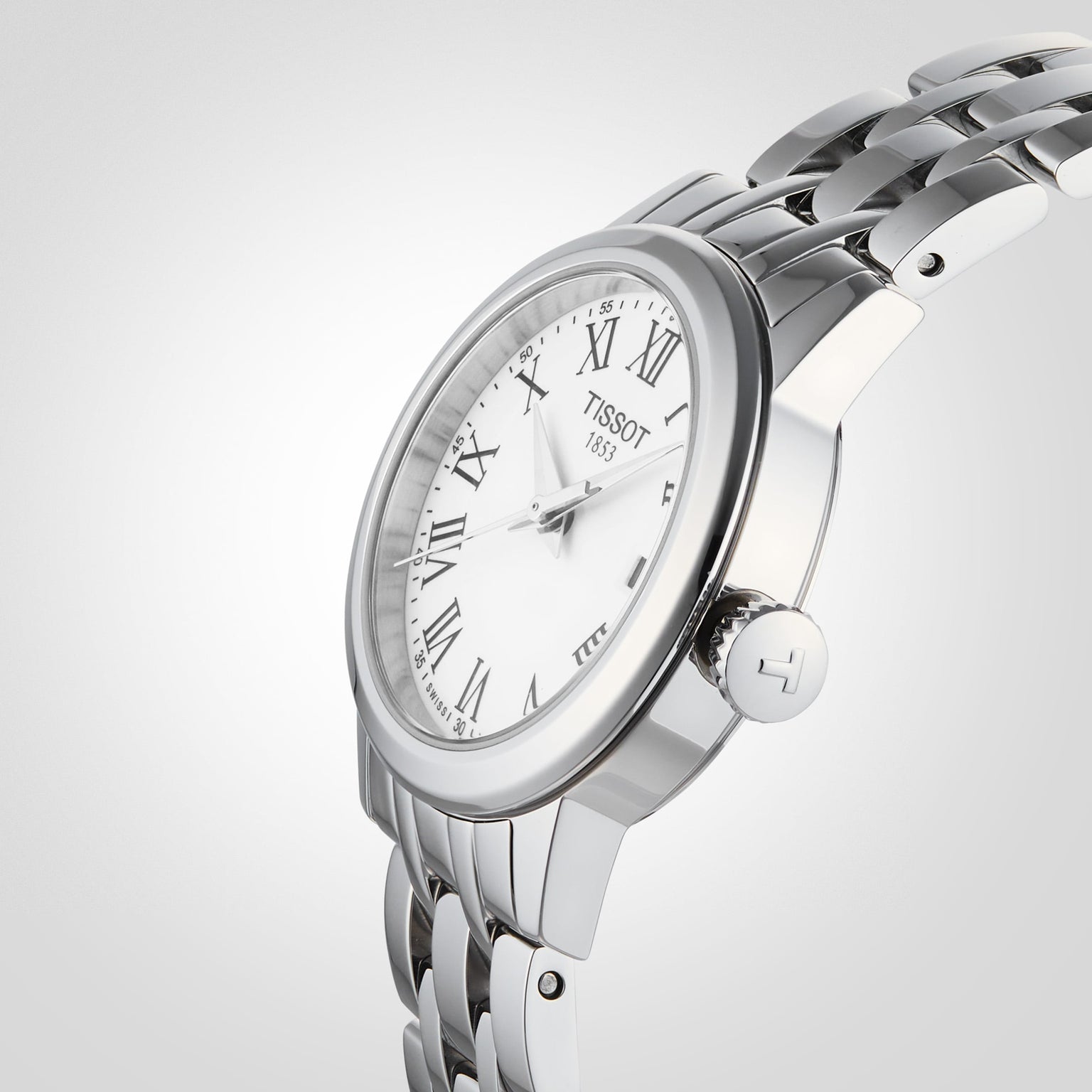 The Tissot Classic Dream wristwatch features a silver metal link band, white dial with Roman numerals, and exudes luxury and style against a light background.