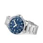 The Tissot Seastar 1000 Powermatic 80 is a silver divers watch with a blue dial and bezel, white hour markers, and a stainless steel bracelet, displayed at an angle.