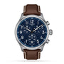 The Tissot Chrono XL Vintage features a blue dial with white numerals, three subdials, a date display at 4 oclock, and a brown leather strap with white stitching for classic style.