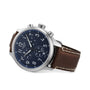 The Tissot Chrono XL Vintage watch features a silver case, blue dial with white numerals, and brown leather strap, shown angled on a white background to showcase its elegant, vintage-inspired design.