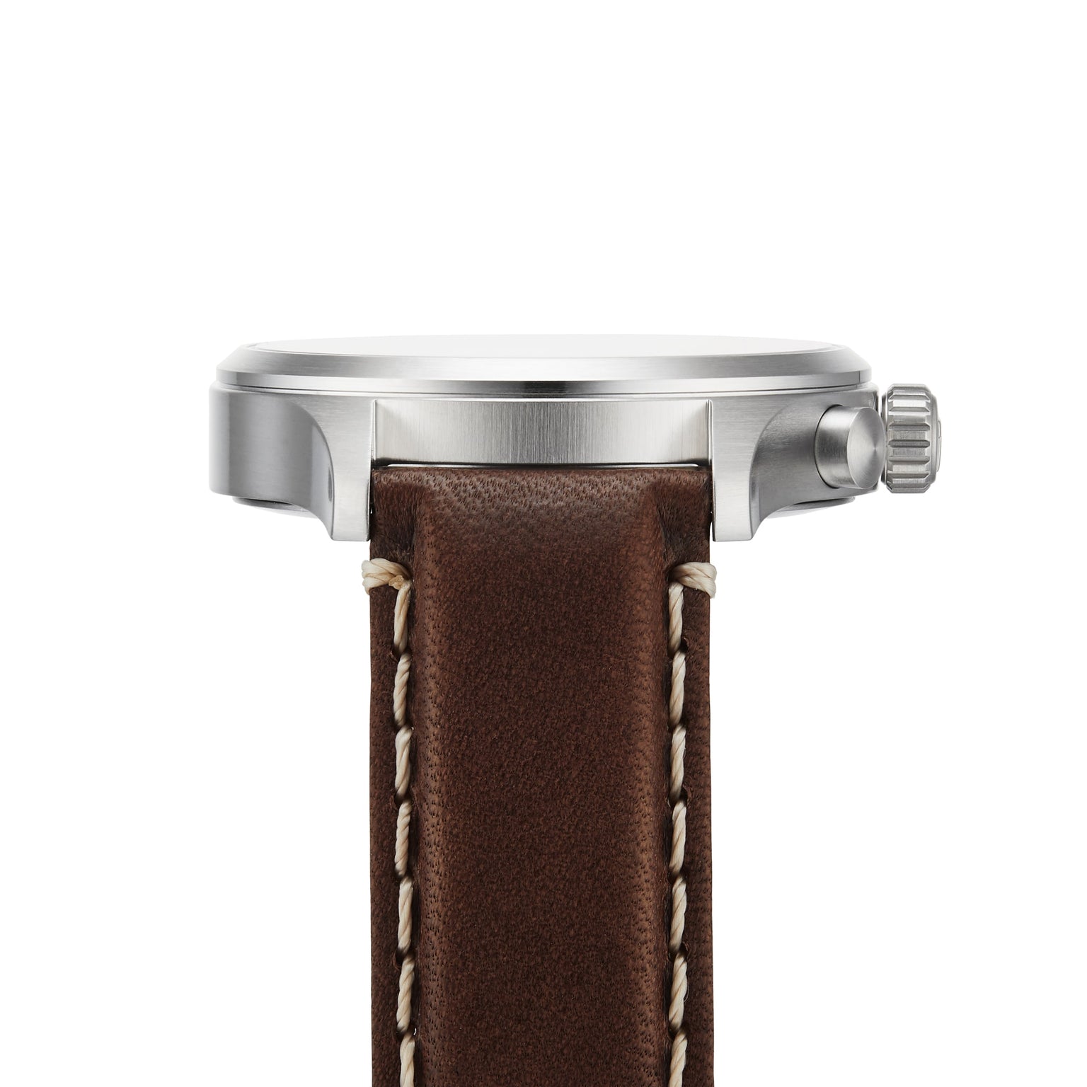 Side view of the Tissot Chrono XL Vintage, an elegant watch with a round silver case, textured crown, and brown leather strap with white stitching and vintage-inspired style.