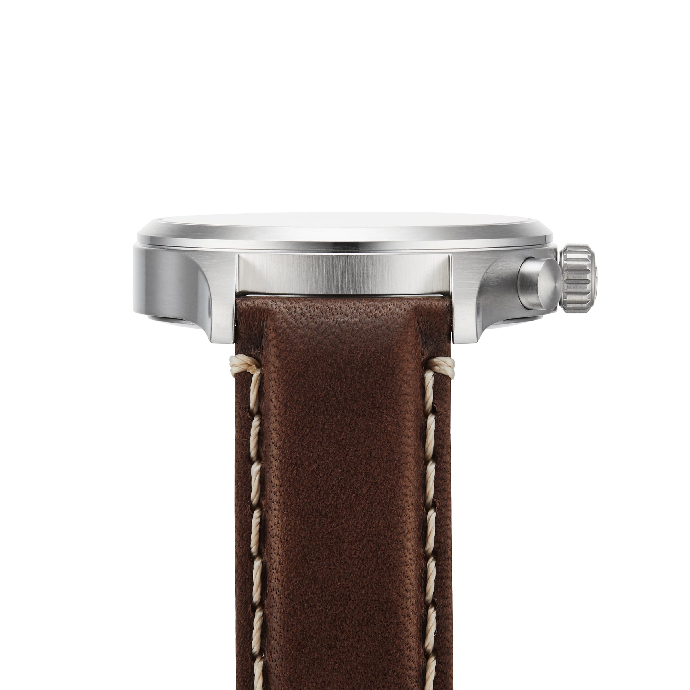 Side view of the Tissot Chrono XL Vintage, an elegant watch with a round silver case, textured crown, and brown leather strap with white stitching and vintage-inspired style.