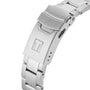 The Tissot Seastar 1000 features a silver metal clasp with a T logo, secured to a polished metal band, shown isolated on white.