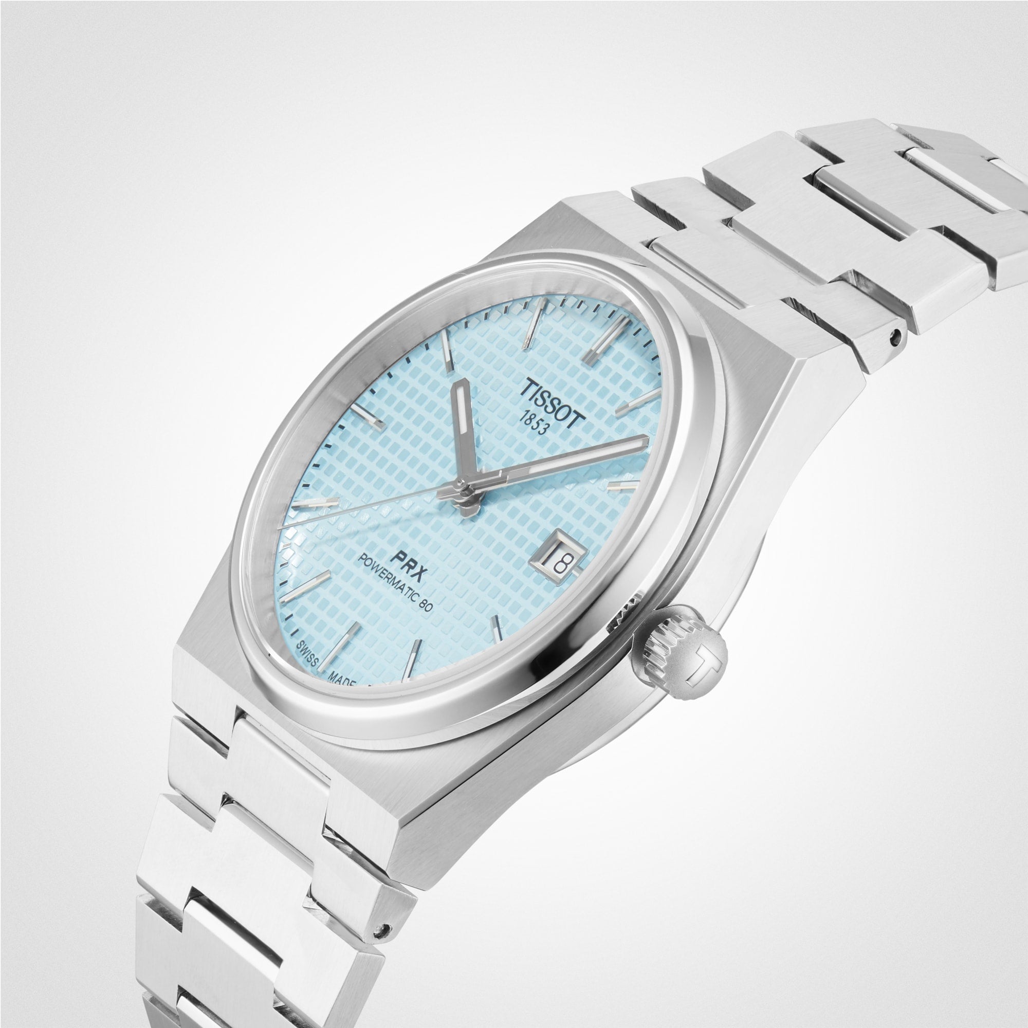 A Tissot PRX Powermatic 80 wristwatch with a silver stainless steel case and bracelet, light blue textured dial, and date display is shown against a plain white background.