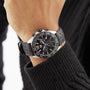 A person in a black sweater wears a TAG Heuer Formula 1 Chronograph with a black dial on their left wrist.