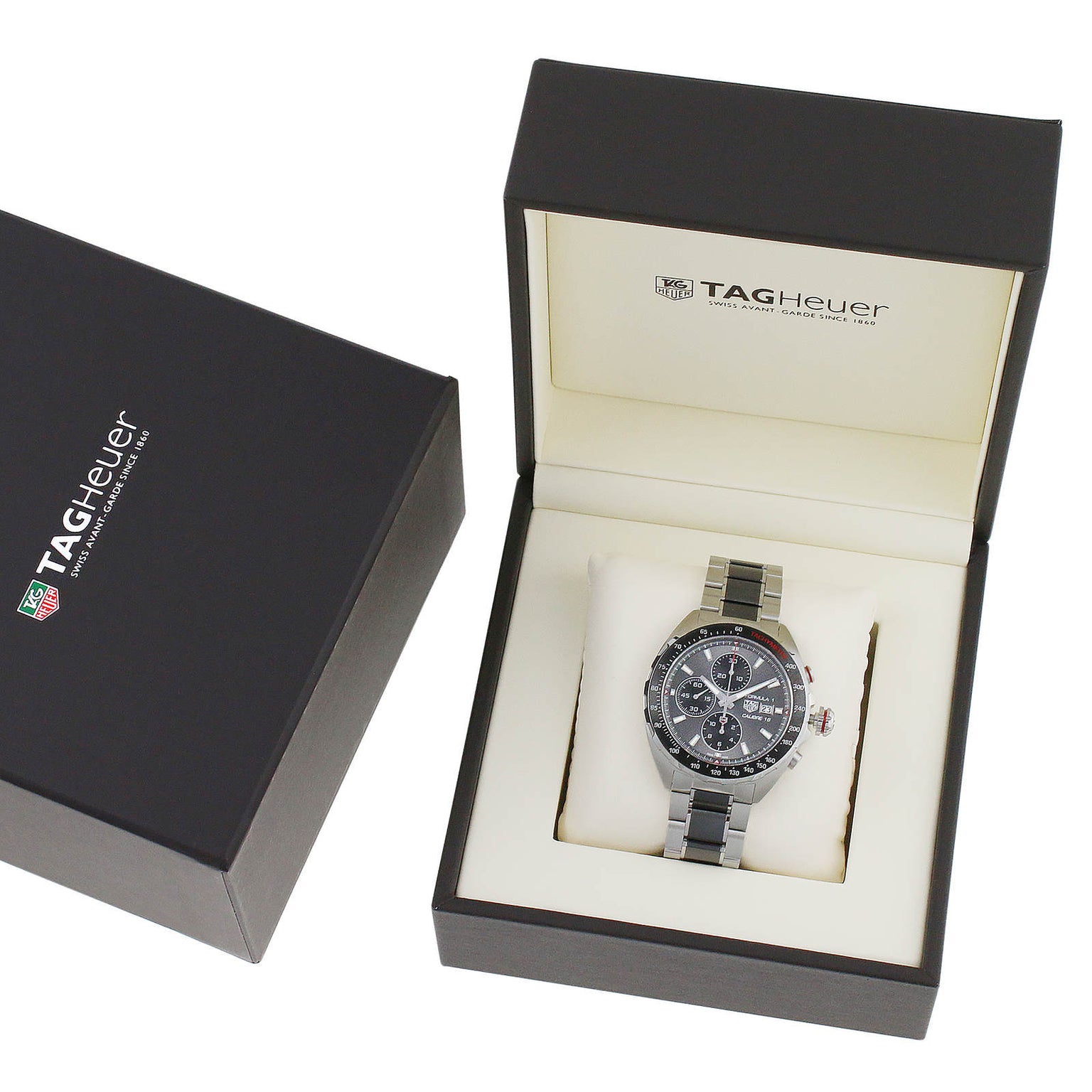 A TAG Heuer Formula 1 Chronograph wristwatch with a metal band is shown in an open branded box, featuring the TAG Heuer logo on the lid and equipped with a precision calibre 16 movement.