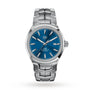 The TAG Heuer Link Date is a stainless steel men’s watch with a blue dial, silver hour markers, date at 3 o’clock, metal link bracelet, and sapphire crystal glass.