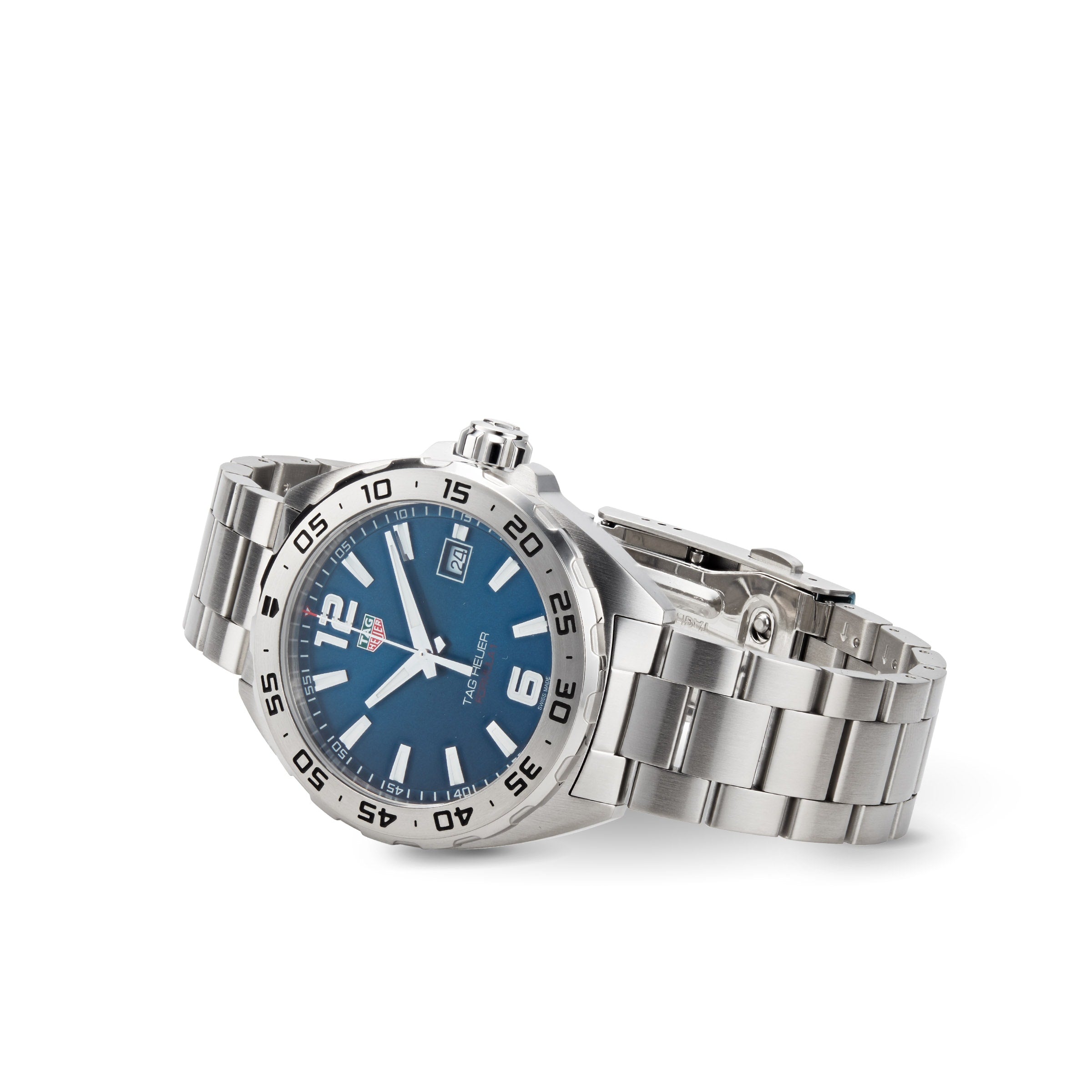 A TAG Heuer Formula 1 Date stainless steel watch with a blue dial, luminous hands, date window, and link bracelet is shown on a white background.