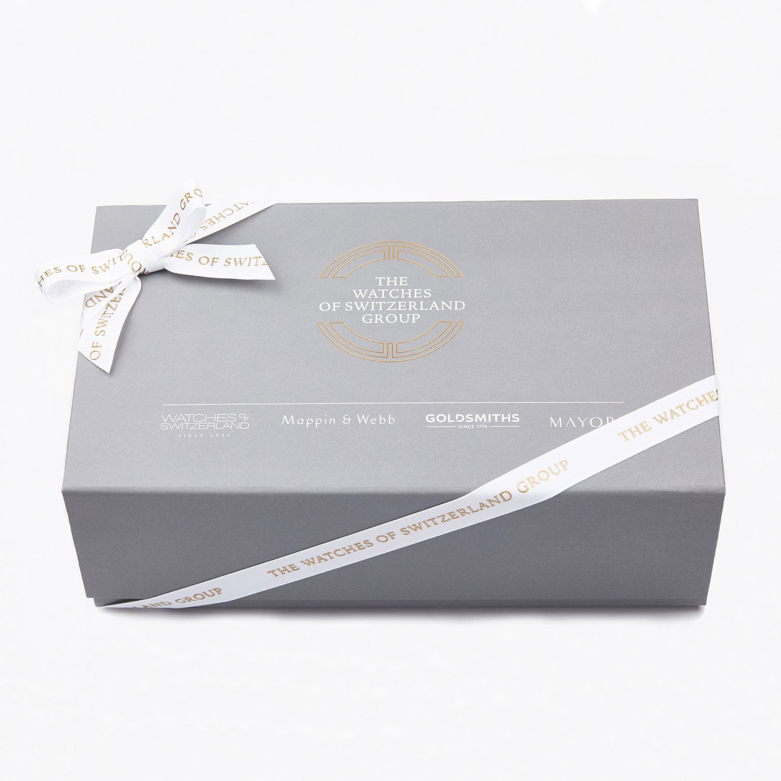 A grey gift box with a white ribbon, displaying The Watches of Switzerland Group logo and brands like Mappin & Webb, Goldsmiths, and Mayors—a perfect presentation for the TAG Heuer Formula 1 Date watch.