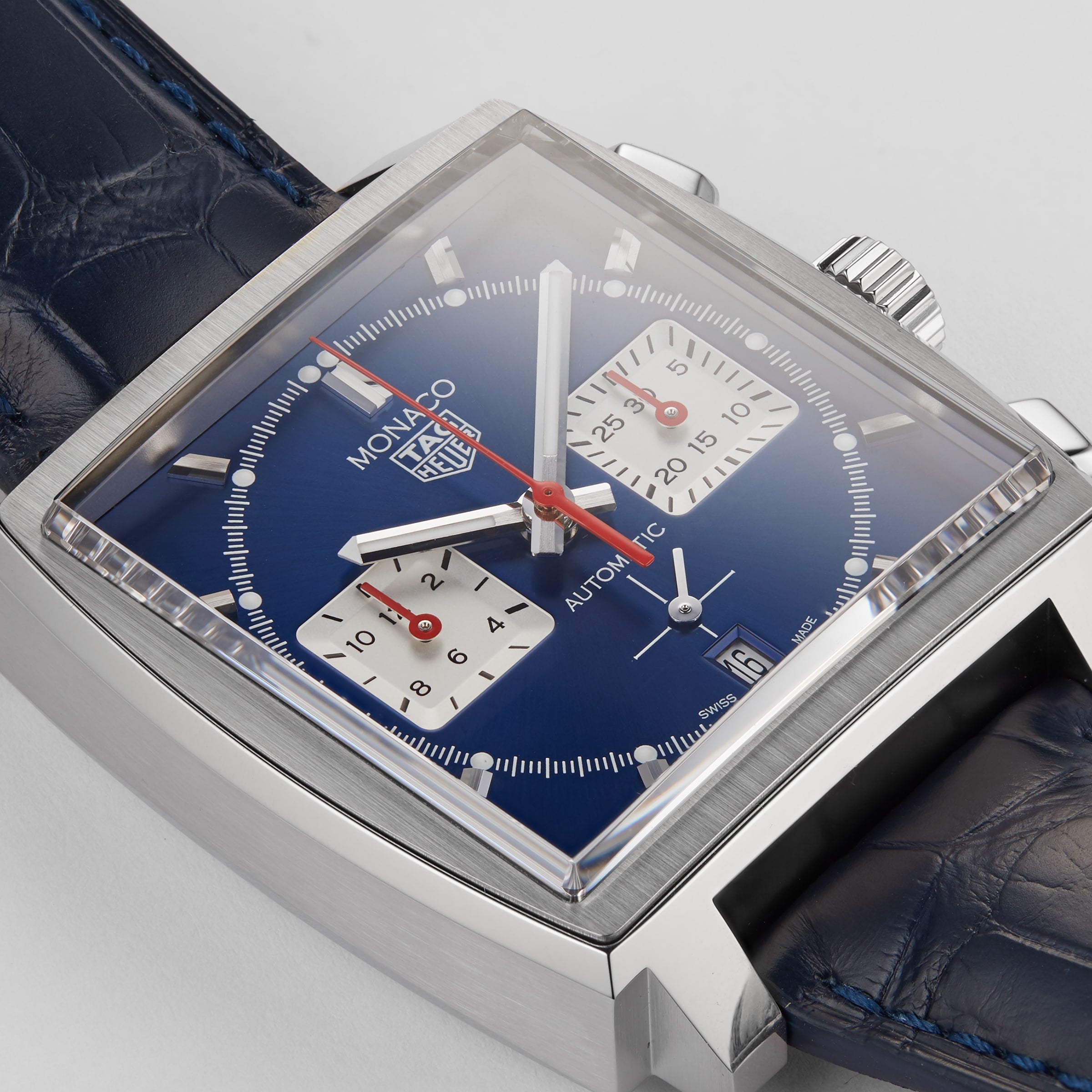 Close-up of the TAG Heuer Monaco Chronograph: square face, blue dial, two white subdials, red hands, and a blue leather strap—powered by the advanced Heuer 02 movement.