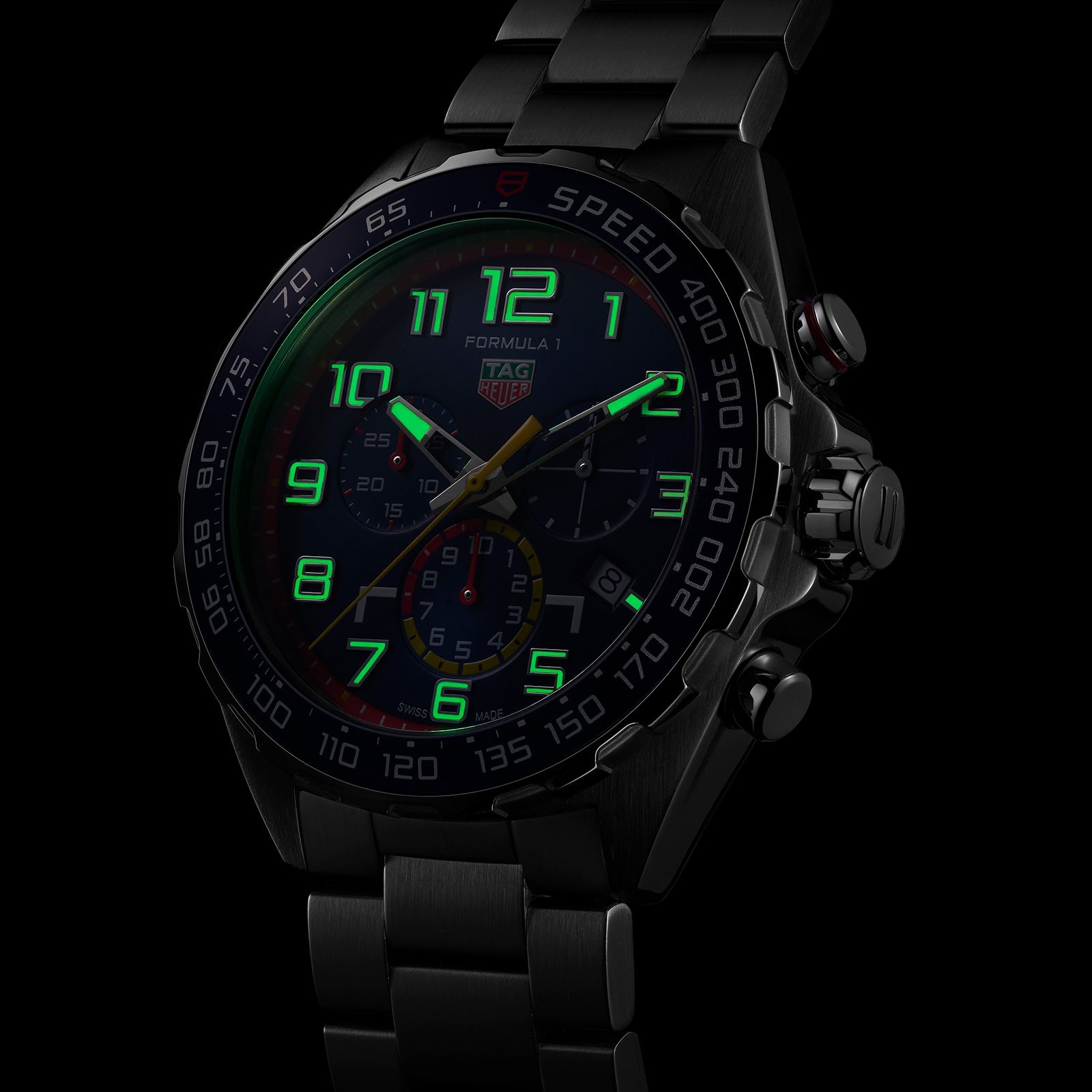 The TAG Heuer Special Edition Formula 1 Chronograph x Red Bull Racing features illuminated green numerals and hands on a dark background, inspired by Red Bull Racing and crafted in sleek black metal.