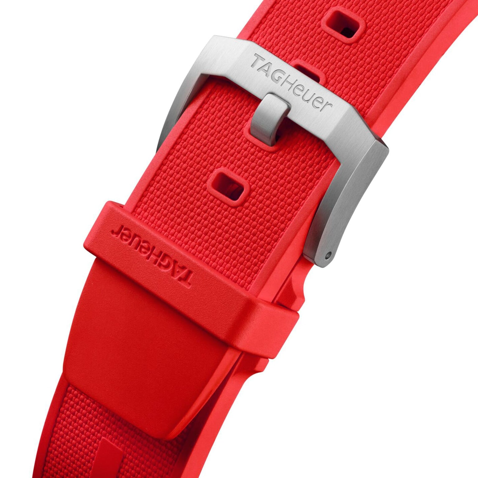 Close-up of a red textured rubber strap from the TAG Heuer Formula 1 Chronograph, featuring a silver buckle engraved with the brand name and emphasizing its sporty design inspired by the iconic collection.
