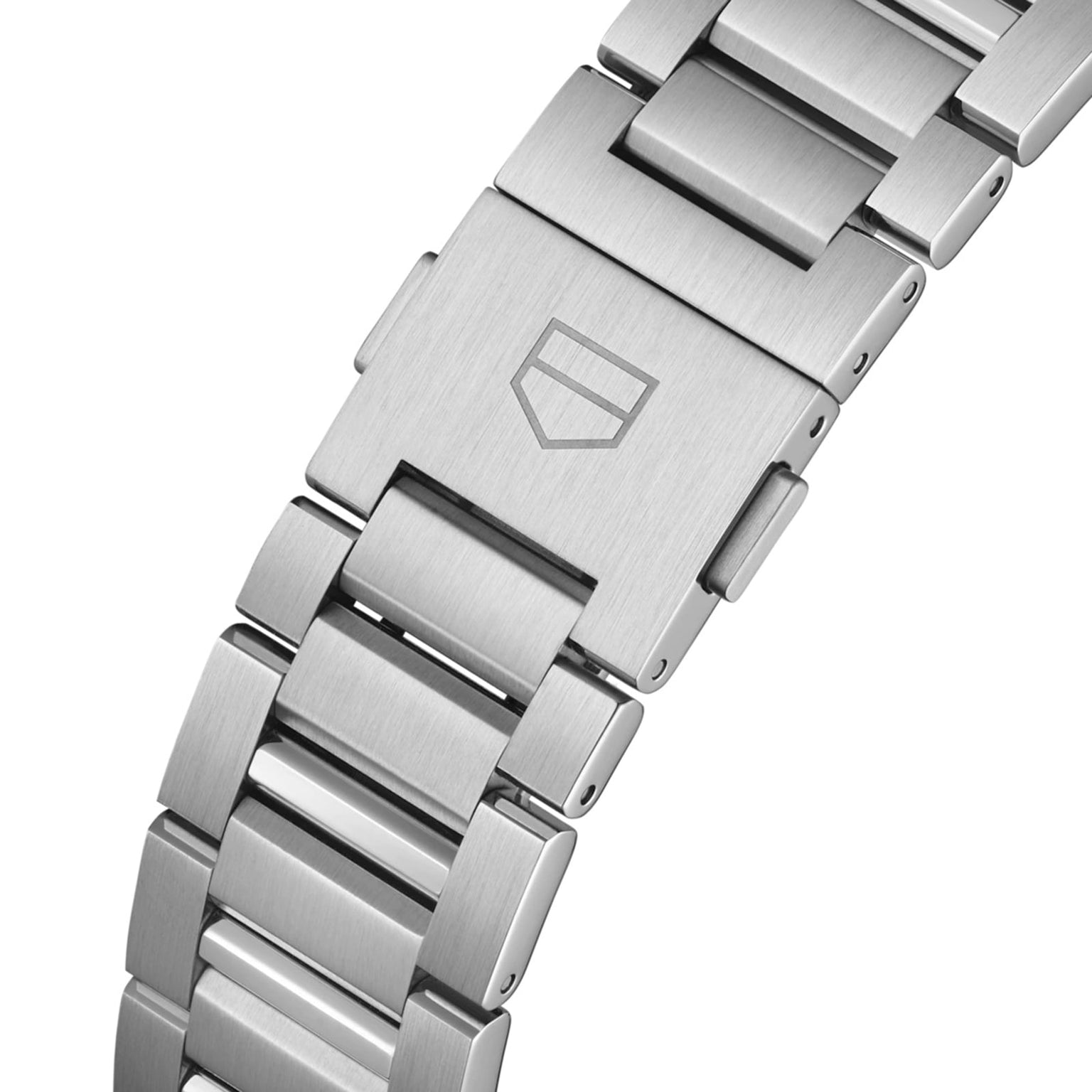Close-up of a TAG Heuer Carrera Chronographs stainless steel bracelet, showing the clasp with engraved shield logo and part of the ceramic bezel.