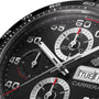 Close-up of the TAG Heuer Carrera Chronograph watch face, featuring hands, subdials, and date display. White and red numerals on black showcase its precision and endurance.