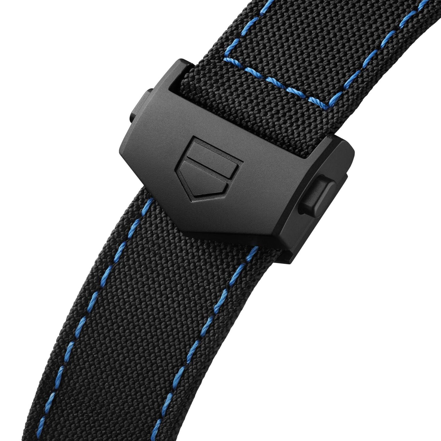 Close-up of a black fabric strap with blue stitching and matte black clasp bearing TAG Heuers shield logo, inspired by Monza motorsports and crafted for the Monza Flyback Chronometer’s COSC-certified precision.