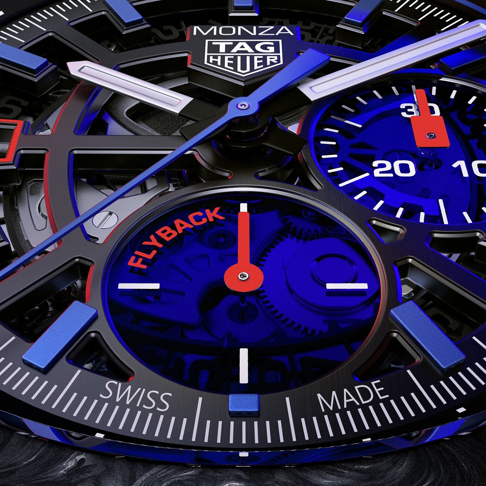 Close-up of the TAG Heuer Monza Flyback Chronometer watch face with chronograph subdials, Flyback text, COSC certified marking, Swiss Made at the bottom, and black, blue, and red accents inspired by competition motorsports.