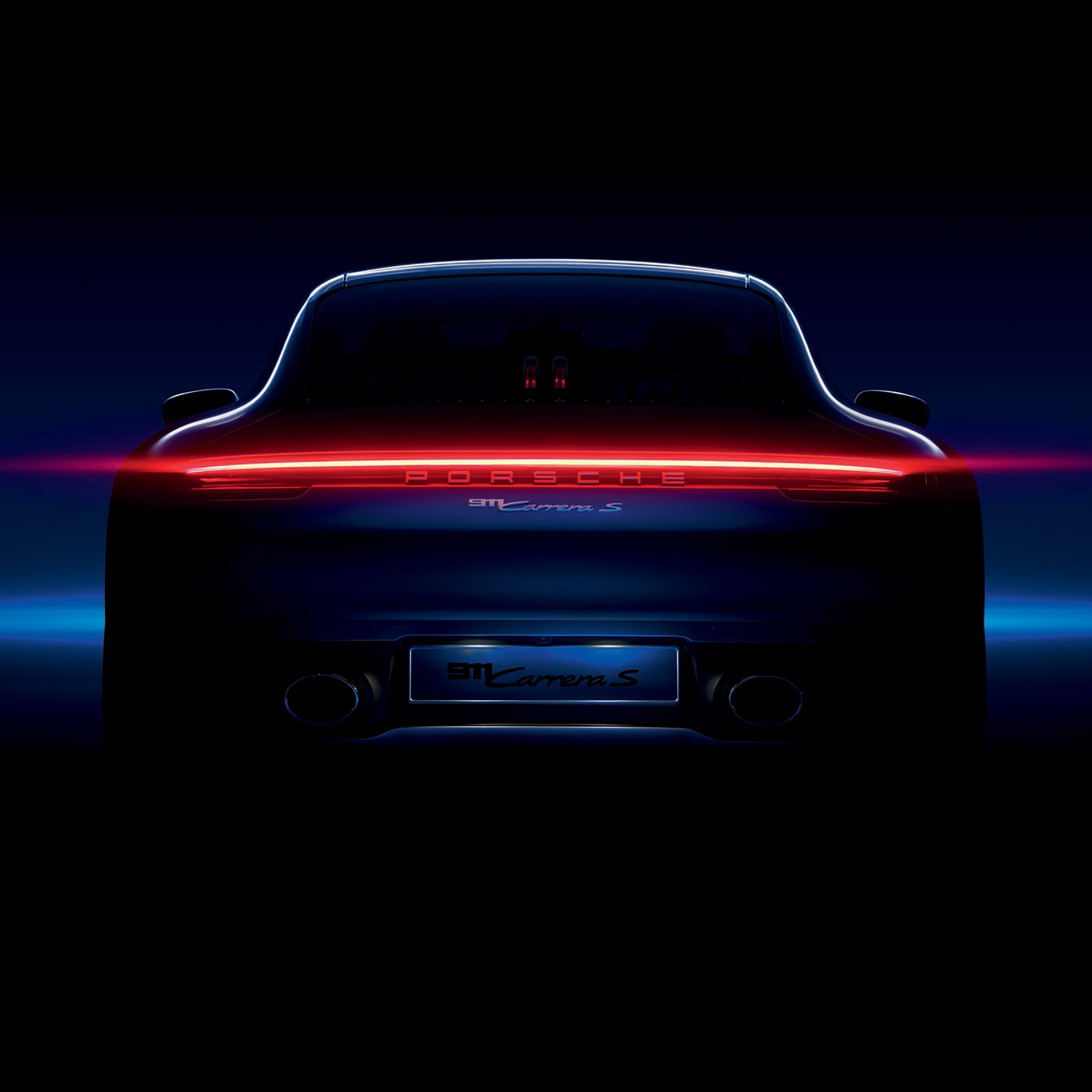 Rear view of a Porsche 911 Carrera S with glowing taillights, set against a dark background—a striking tribute to the legacy behind the TAG Heuer Special Edition Carrera Chronograph x Porsche.