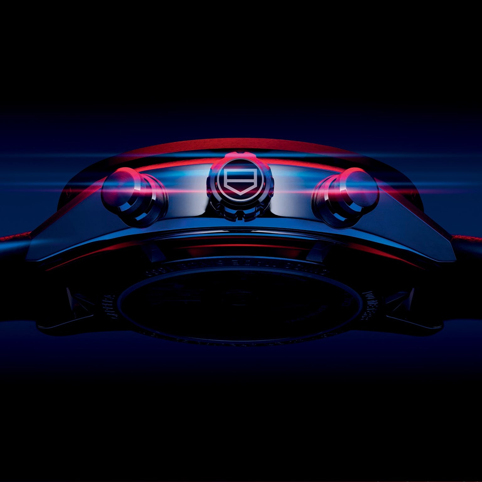 A close-up, low-angle view of the TAG Heuer Special Edition Carrera Chronograph x Porsche wristwatch with illuminated buttons and crown set against a dark, blue-black background.