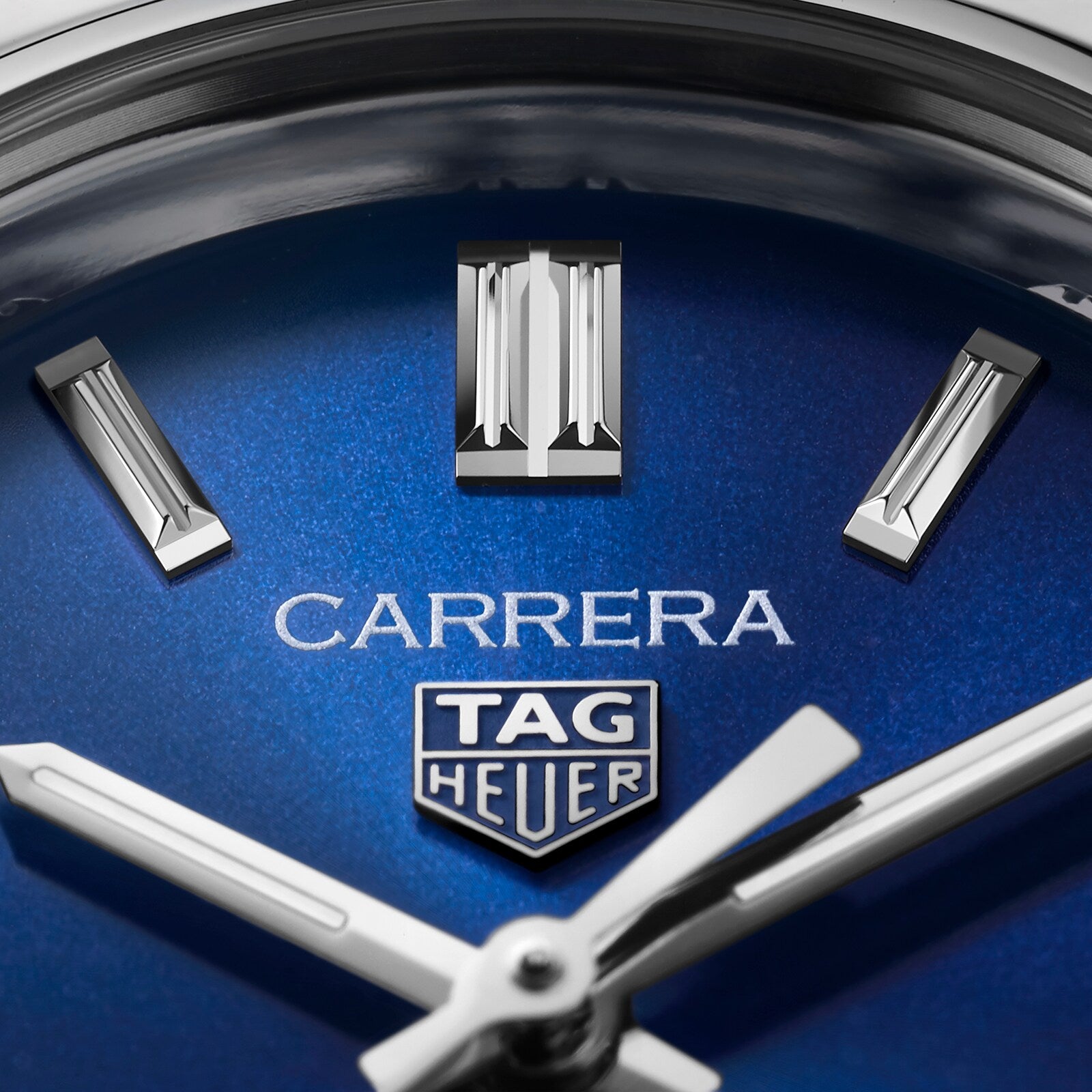 Close-up of the TAG Heuer Carrera Date watch face, showcasing its blue sunray dial, silver hour markers, and sleek hands partially displaying the time.