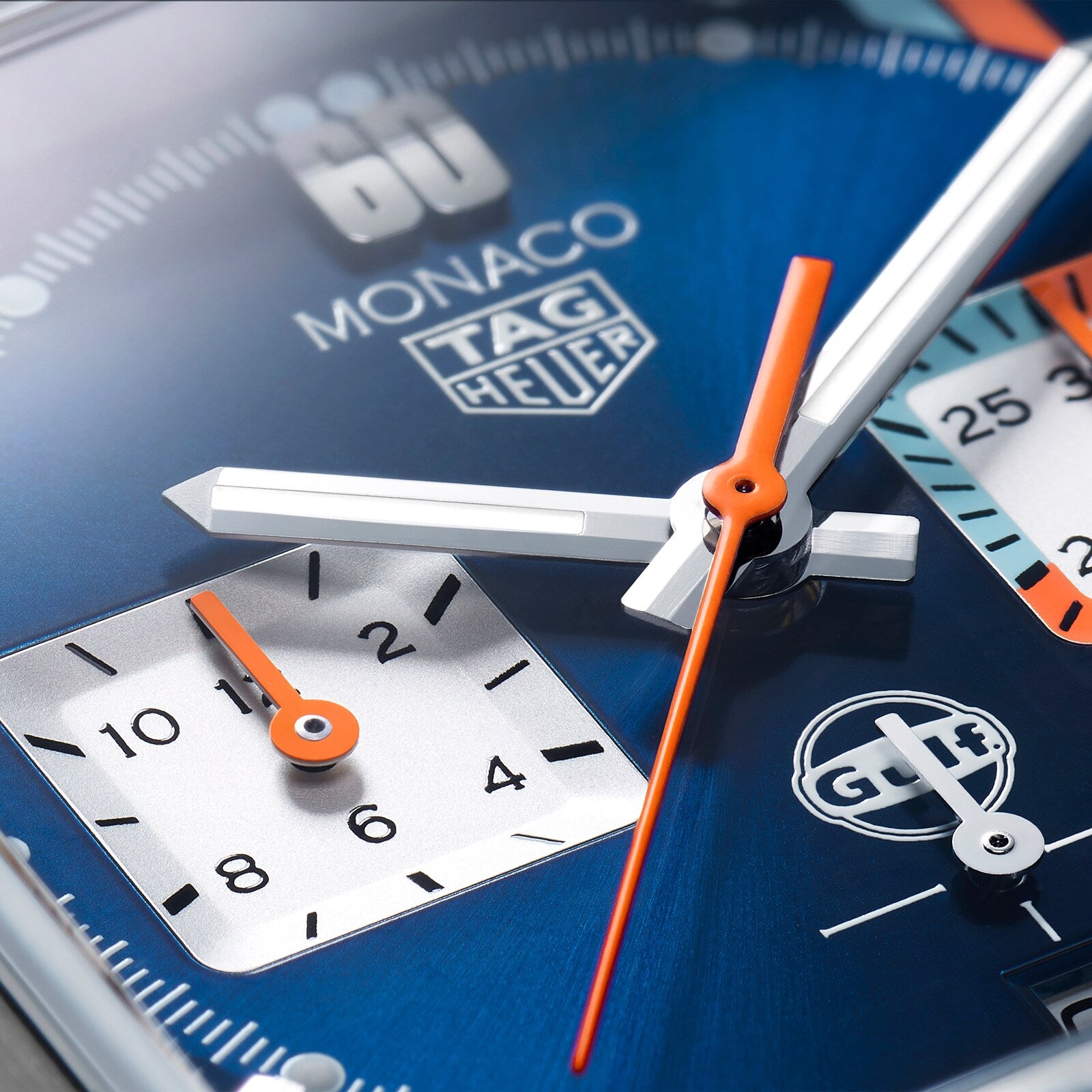 Close-up of the TAG Heuer Special Edition Monaco Gulf watch, featuring a blue face with orange and white hands, subdials, Gulf livery accents, and powered by the automatic Heuer 02 movement.