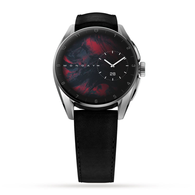 The TAG Heuer Connected Calibre E4 is a modern luxury smartwatch with an avant-garde design, featuring a black leather band, round stainless steel case, and a dark abstract-patterned dial showing time, day, and date.