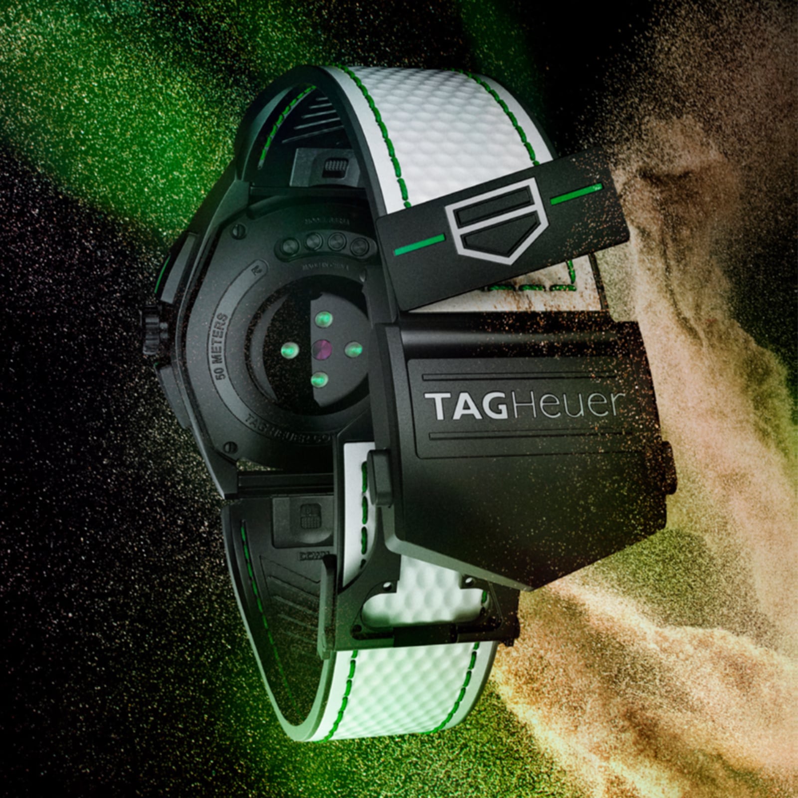The TAG Heuer Connected Calibre E4 Golf Edition smartwatch with a white strap is shown from the back, surrounded by green and gold powder.