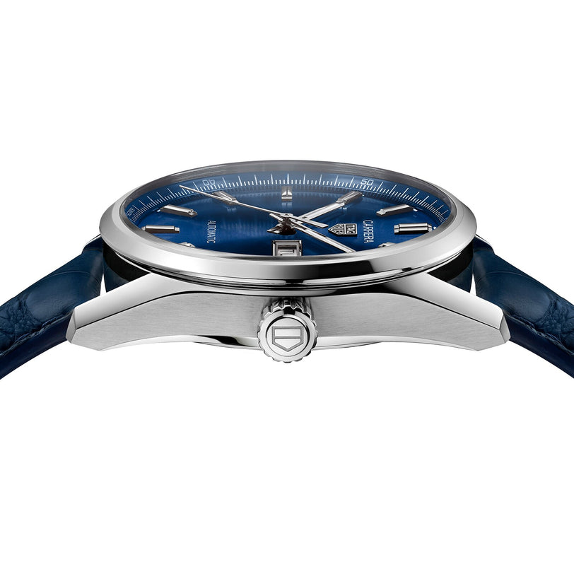 Side view of the TAG Heuer Carrera Day-Date stainless steel watch, featuring a blue dial, blue alligator leather strap, crown detail, and showcasing its thickness and Calibre 5 automatic movement.