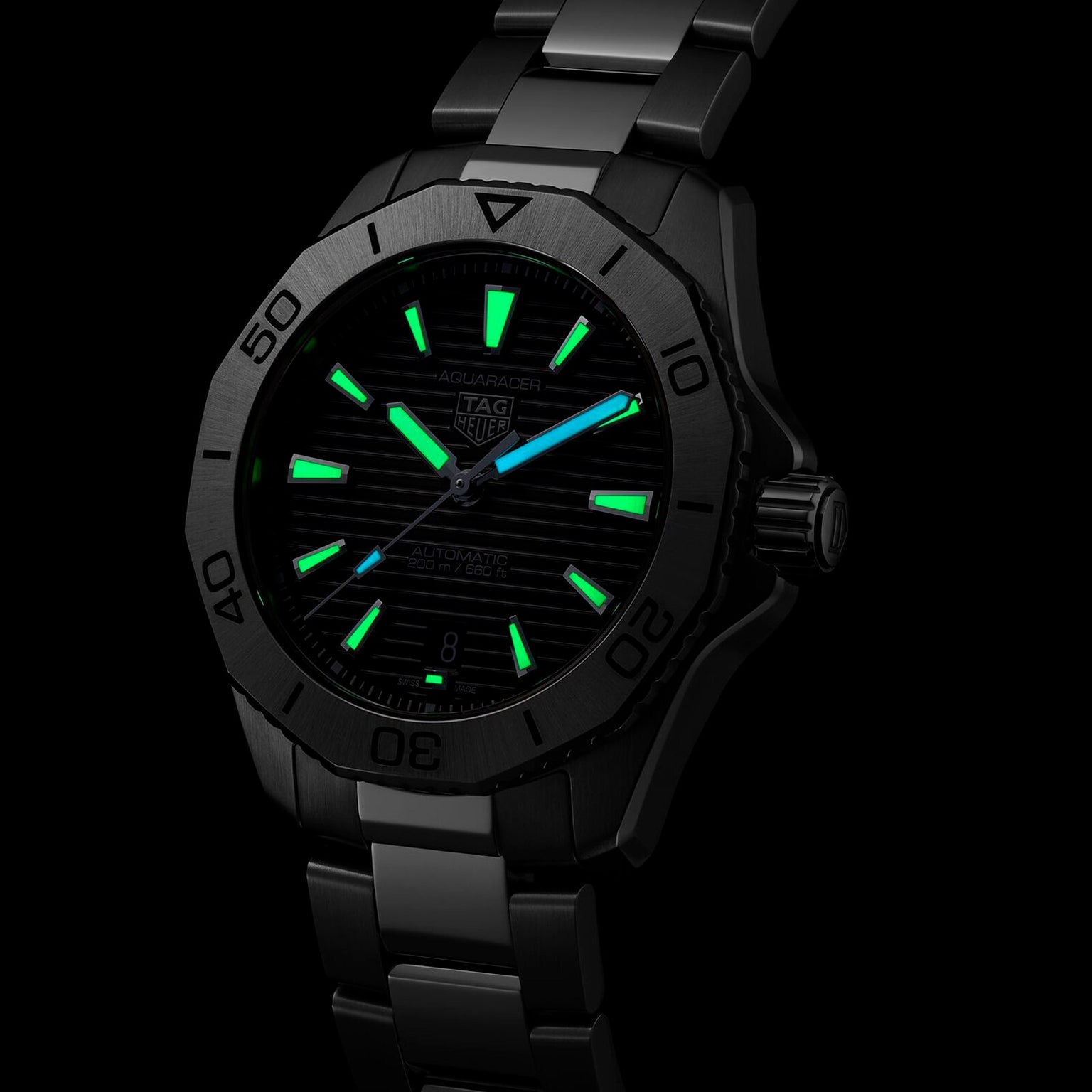 The TAG Heuer Aquaracer Professional 200 Date features a black design with luminescent green and blue hour markers and hands, set against a dark background.
