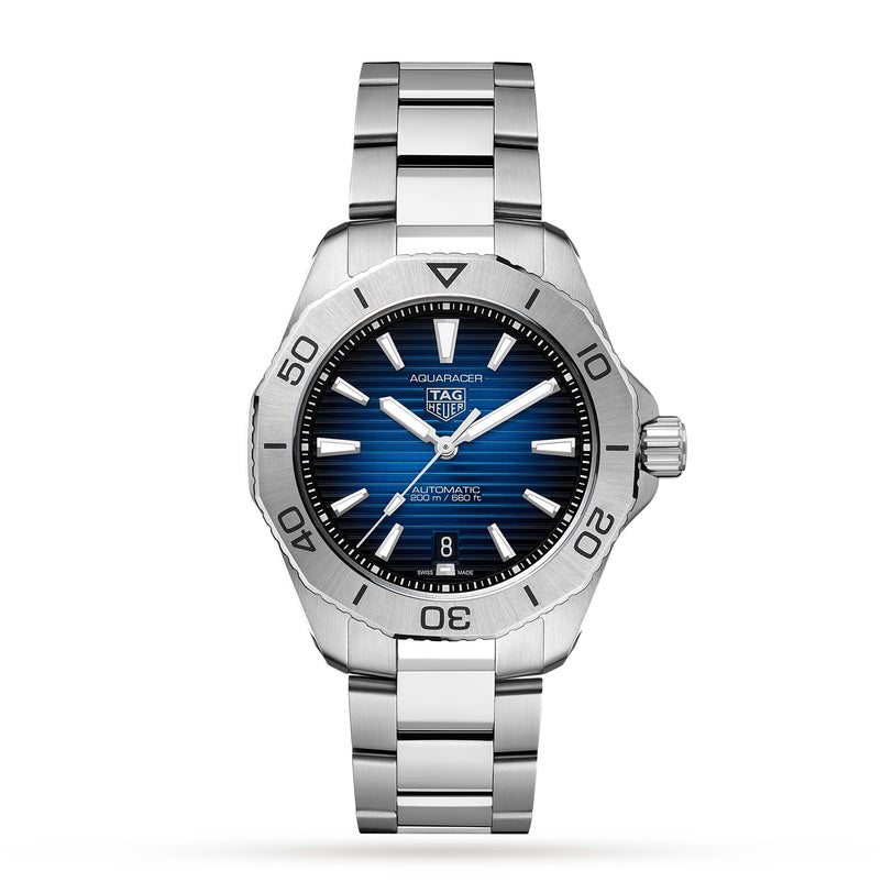 The TAG Heuer Aquaracer Professional 200 Date is a silver diving watch with a blue dial, silver markers, date at 6 o’clock, and a stainless steel case and bracelet, shown against a white background.