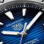 Close-up of a TAG Heuer Aquaracer Professional 200 Date watch face, featuring silver hands and hour markers on a textured blue background, all framed by a sleek stainless steel case.