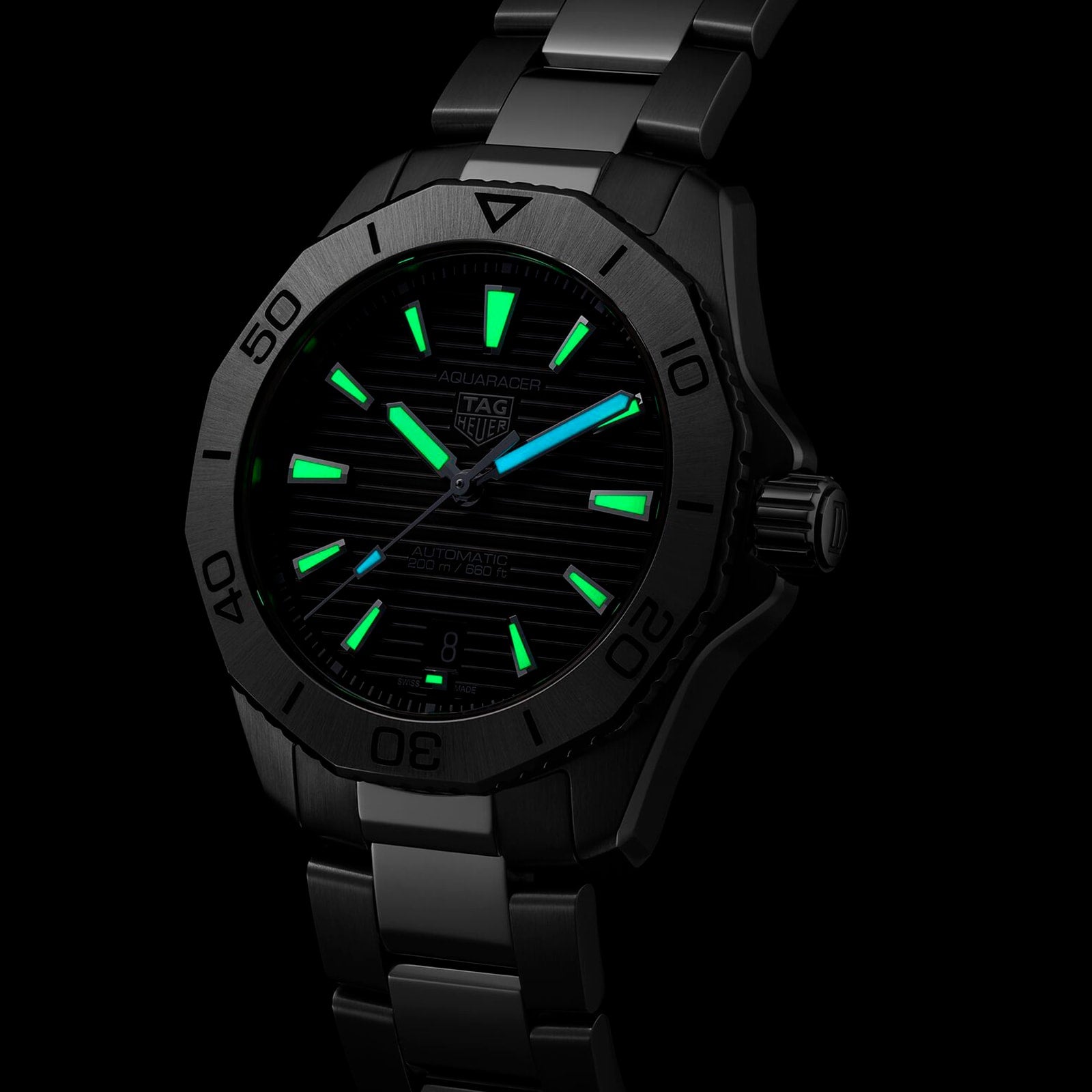 The TAG Heuer Aquaracer Professional 200 Date features a black dial with green and blue luminescent hour markers and hands, complemented by a bold stainless steel case.