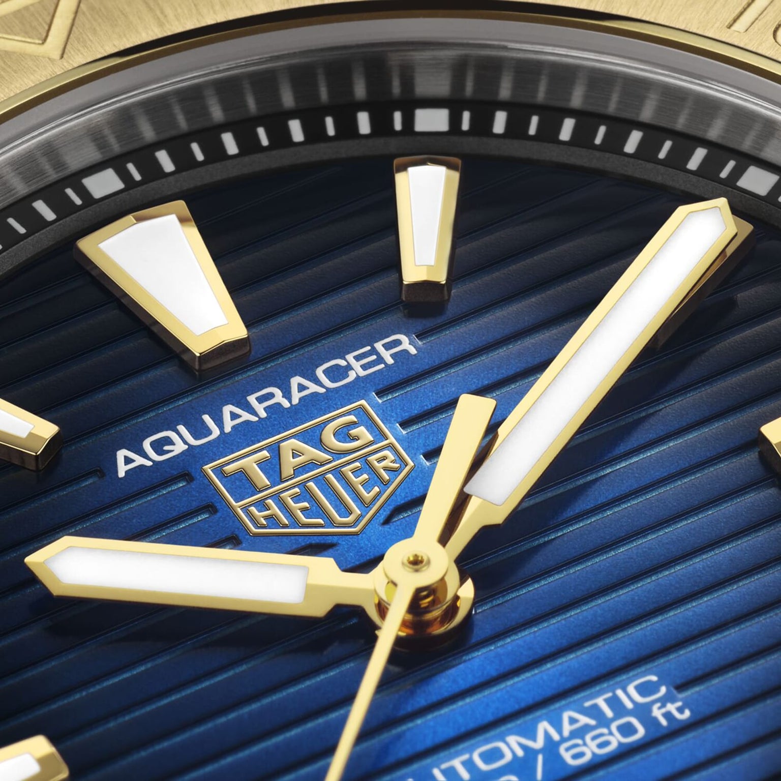 Close-up of the TAG Heuer Aquaracer Professional 200 Date watch face with gold and white hands and markers, a blue striped background, and text noting automatic movement and 200m water resistance—an elegant sports timepiece.