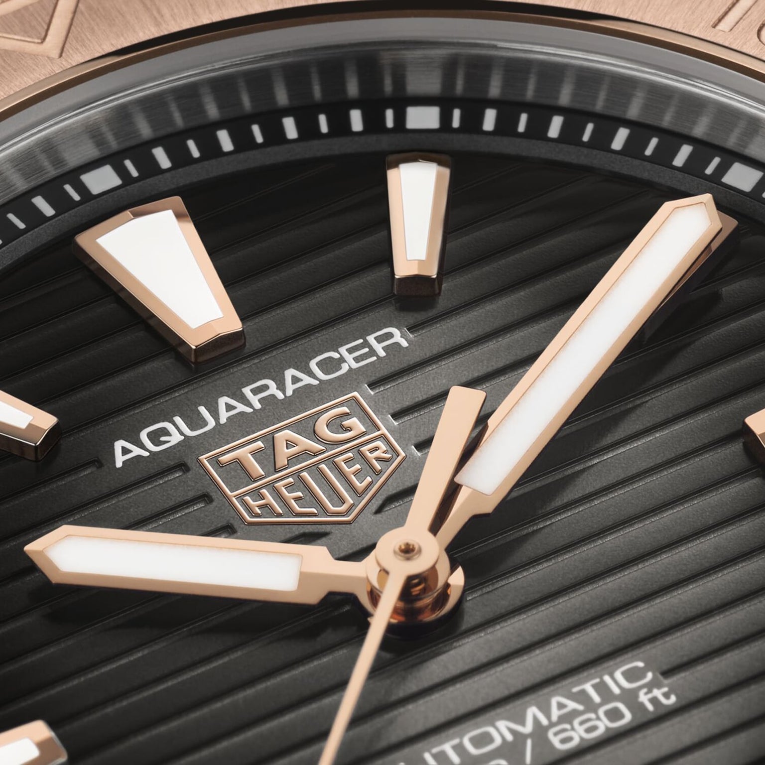 Close-up of a TAG Heuer Aquaracer Professional 200 watch face featuring gold hands and markers, showcasing detailed branding.