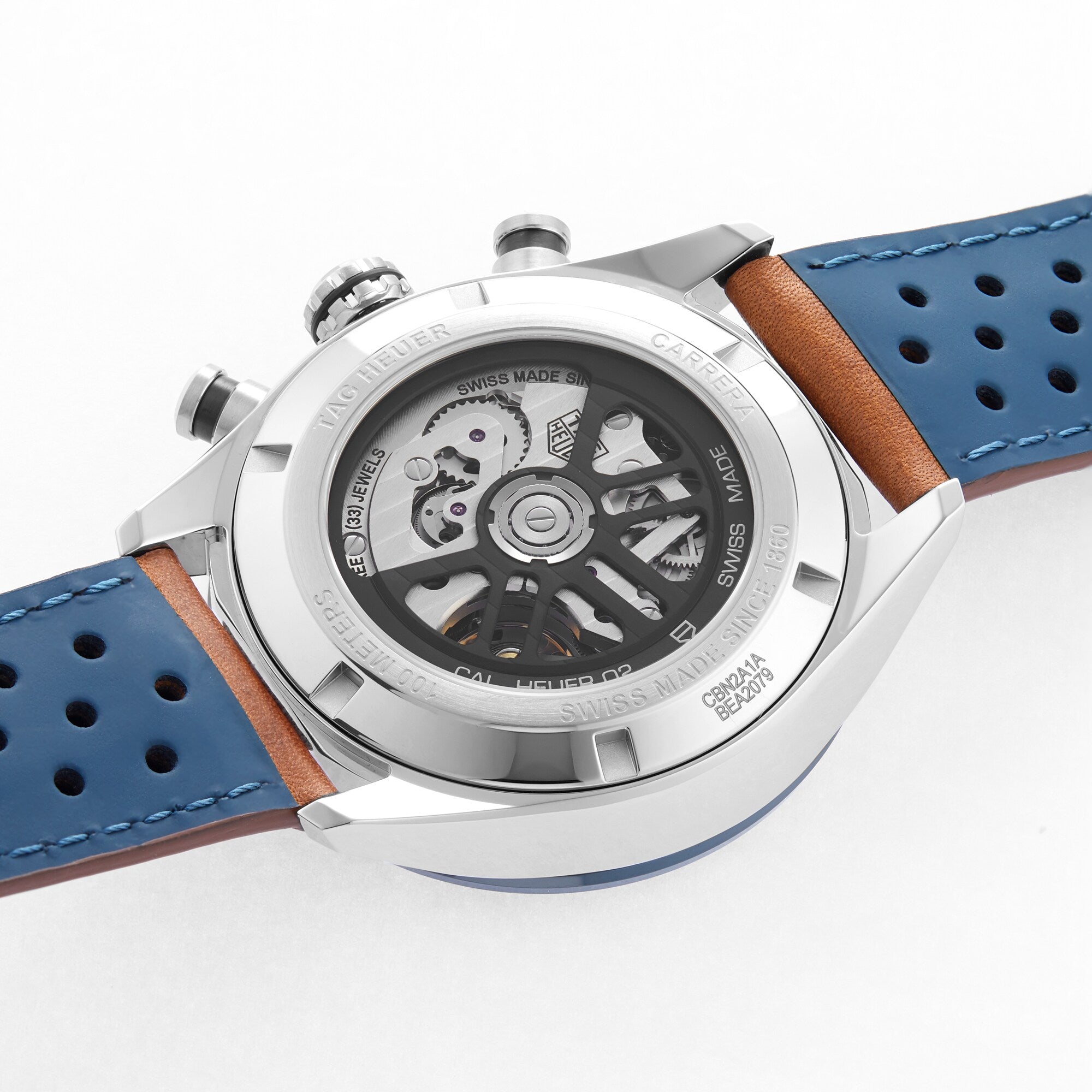 A close-up of the TAG Heuer Carrera Chronograph’s transparent back reveals its intricate mechanical movement and blue strap.