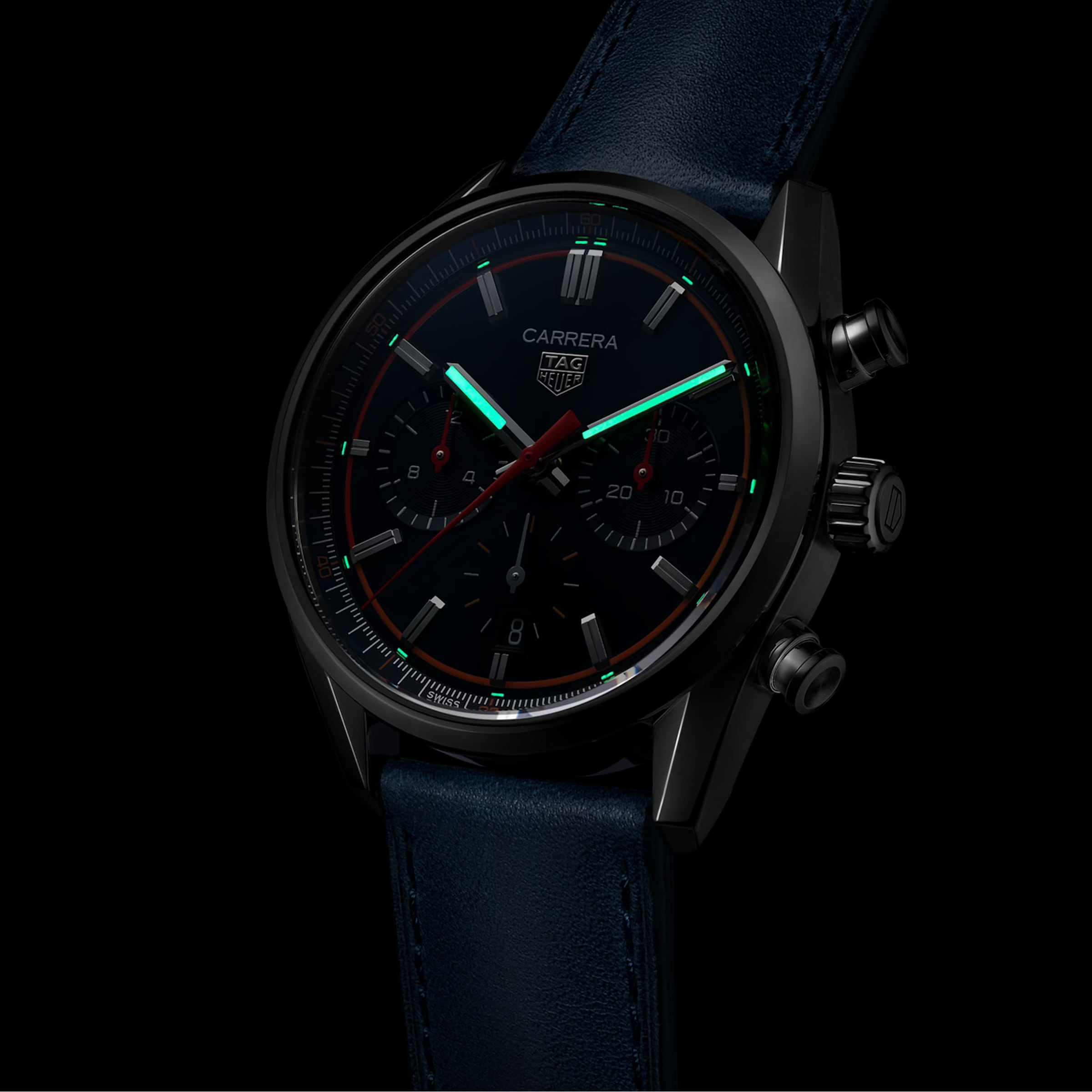 The TAG Heuer Carrera Chronograph features a black dial, luminous hands and markers, Calibre Heuer 02 movement, and a blue leather strap, displayed against a black background.