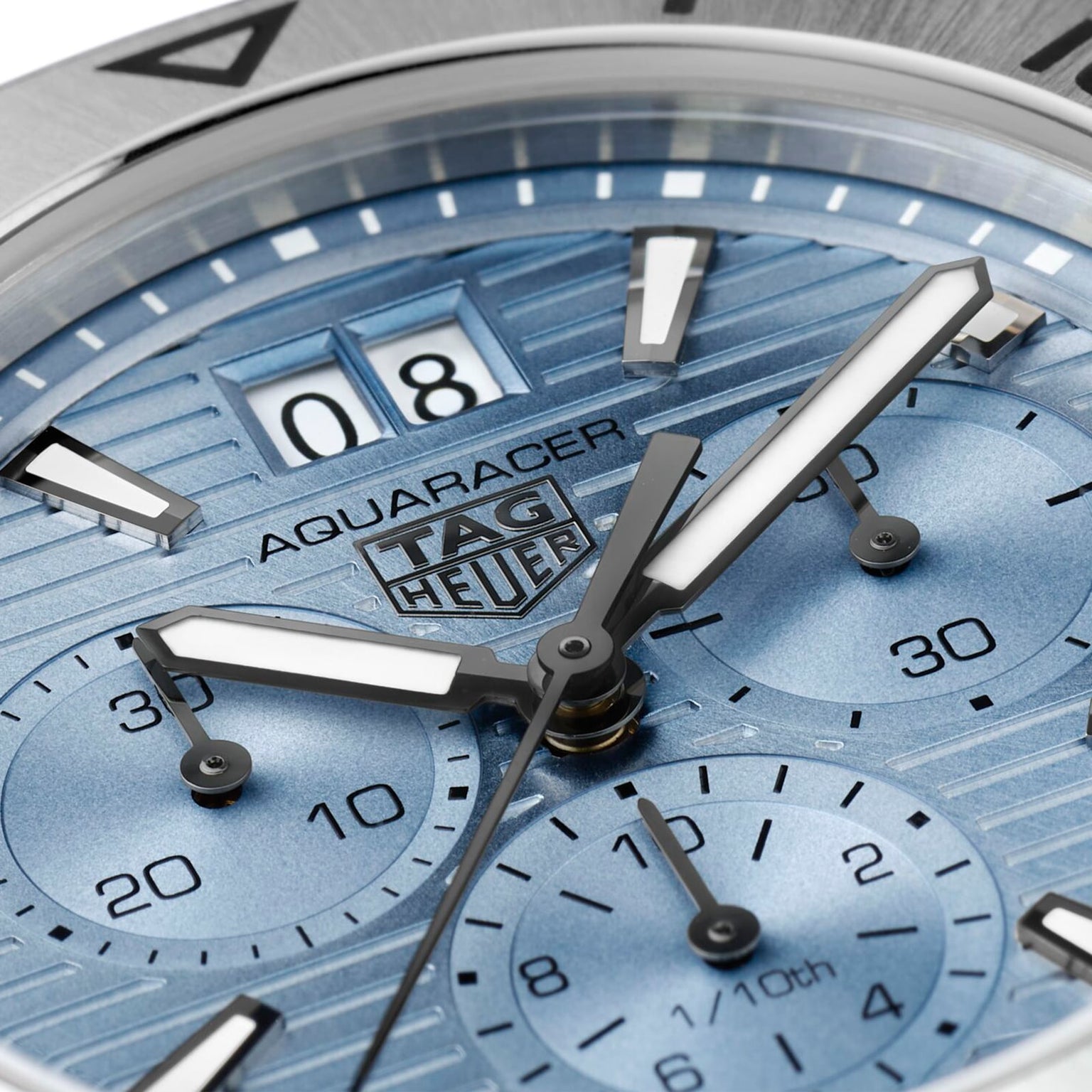 Close-up of the TAG Heuer Aquaracer Professional 200 Chronograph, showcasing its date display, chronograph subdials, and luminous hands on a textured blue dial.